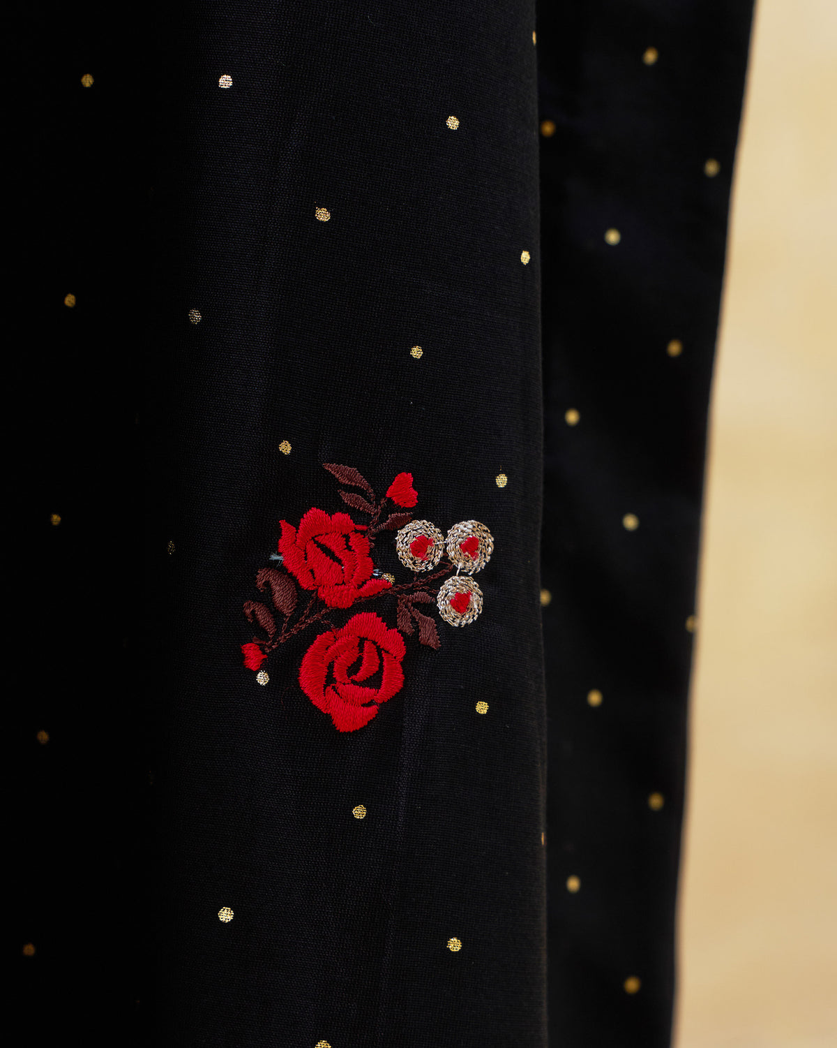 Close-up of red rose embroidery on the black Moonbeam kurta.
