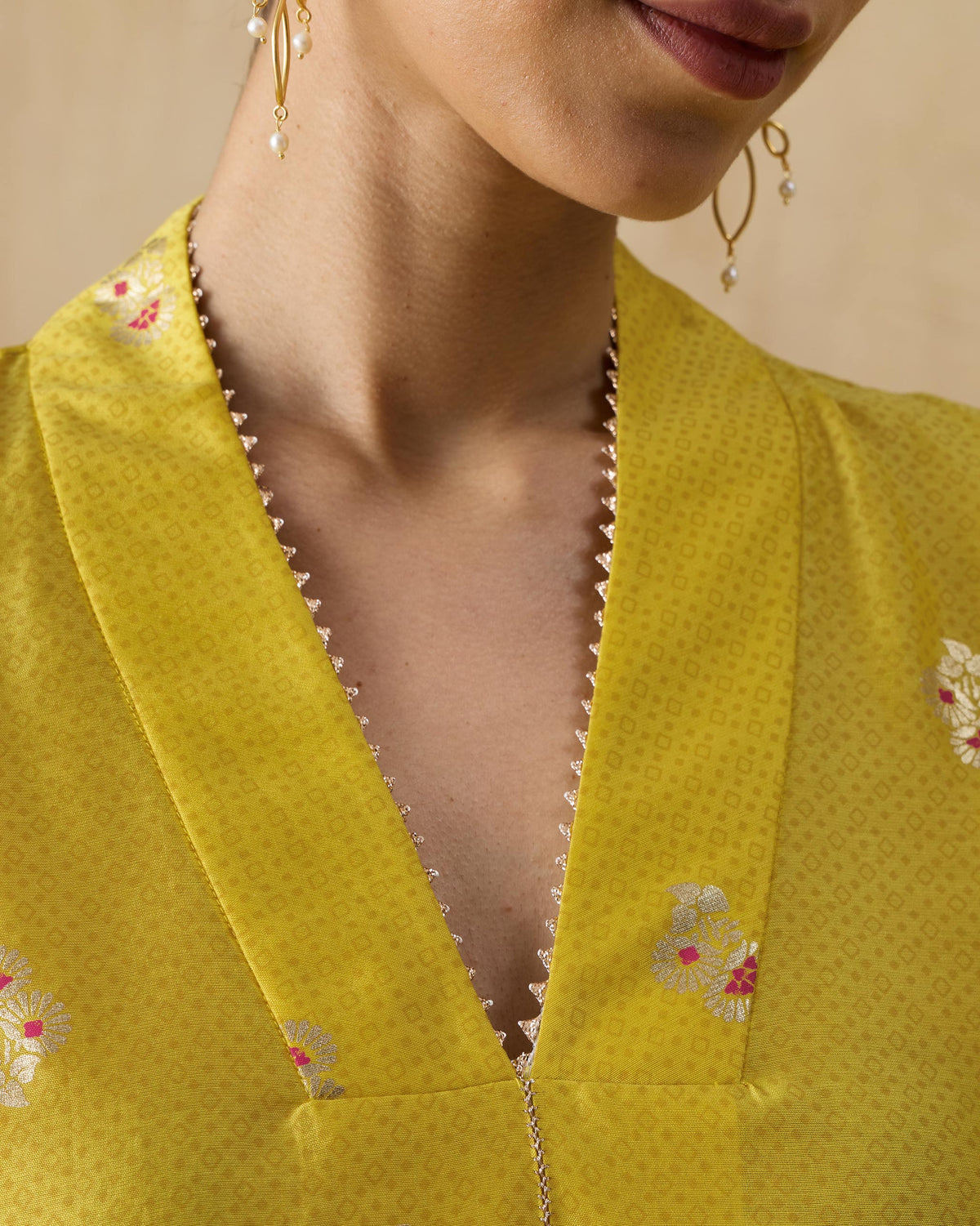 Close-up of the V-neck and floral embroidery on a chartreuse Viva kurta.