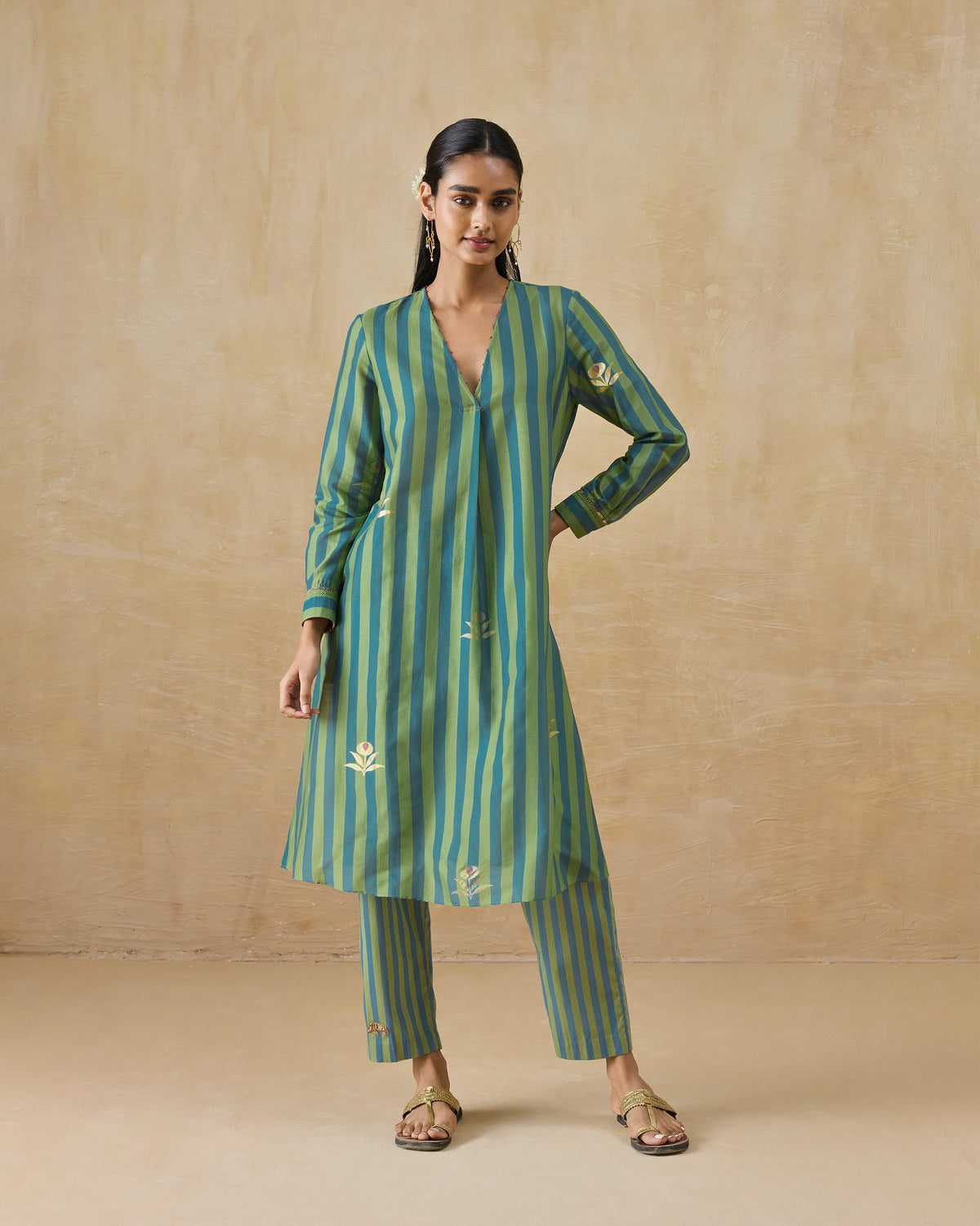 Person wearing a green and teal striped Front Pleated Kurta Set with gold florals.