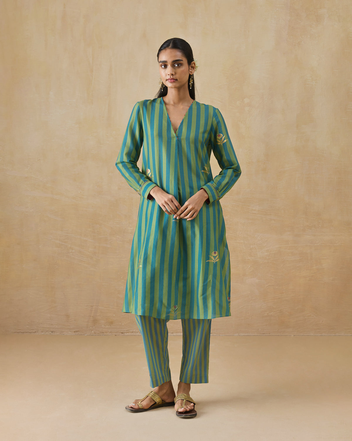 Person wearing a green and teal striped Front Pleated Kurta Set with slim pants.