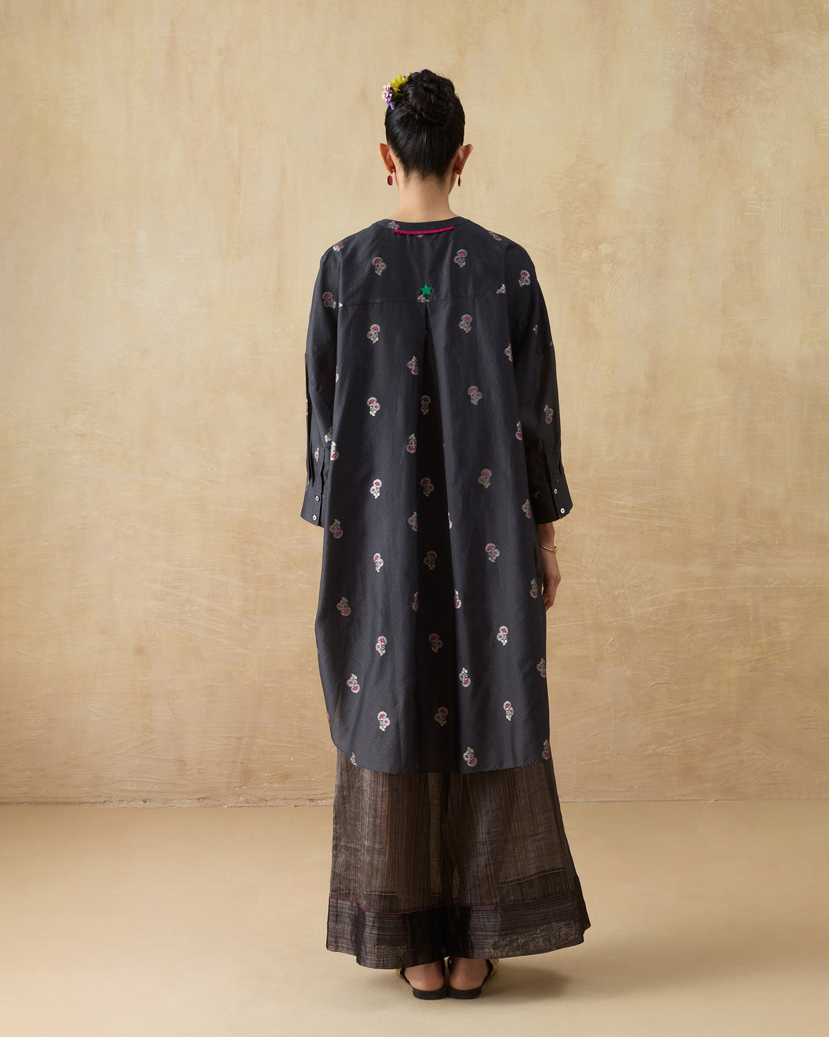 Back of a charcoal floral Lazy Sunday tunic with a green star detail.