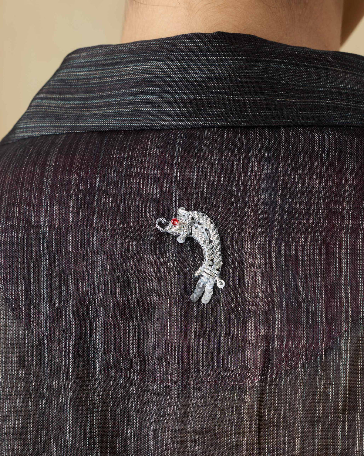 Close-up of the Firefly shirt's silver embroidered motif on the back yoke.