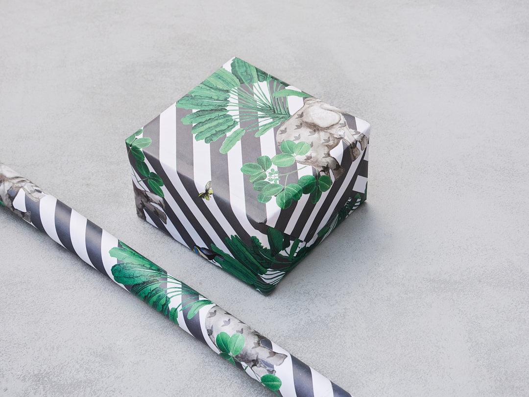 Ele Wrap gift paper with green leaves on grey and white stripes, wrapped around a box.