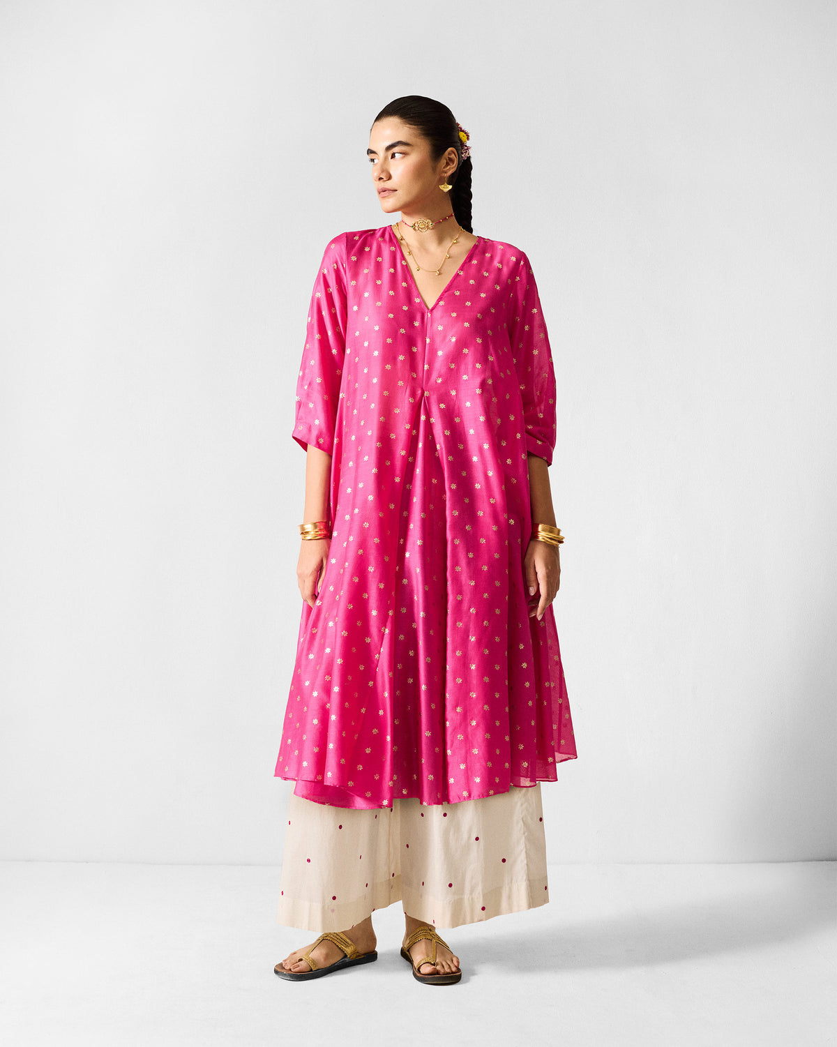 Person wearing a fuchsia Kannauj Kurta with tiny gold floral prints.