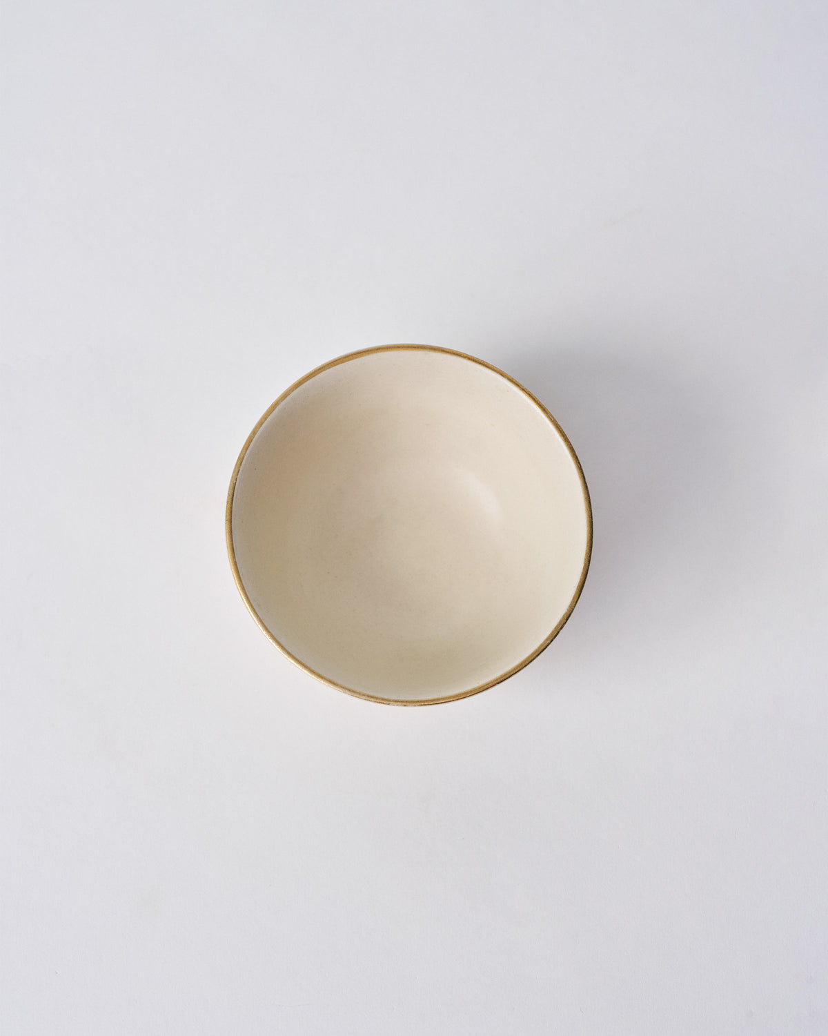 Top view of the Tara Katori, a cream bowl with a thin brown rim.
