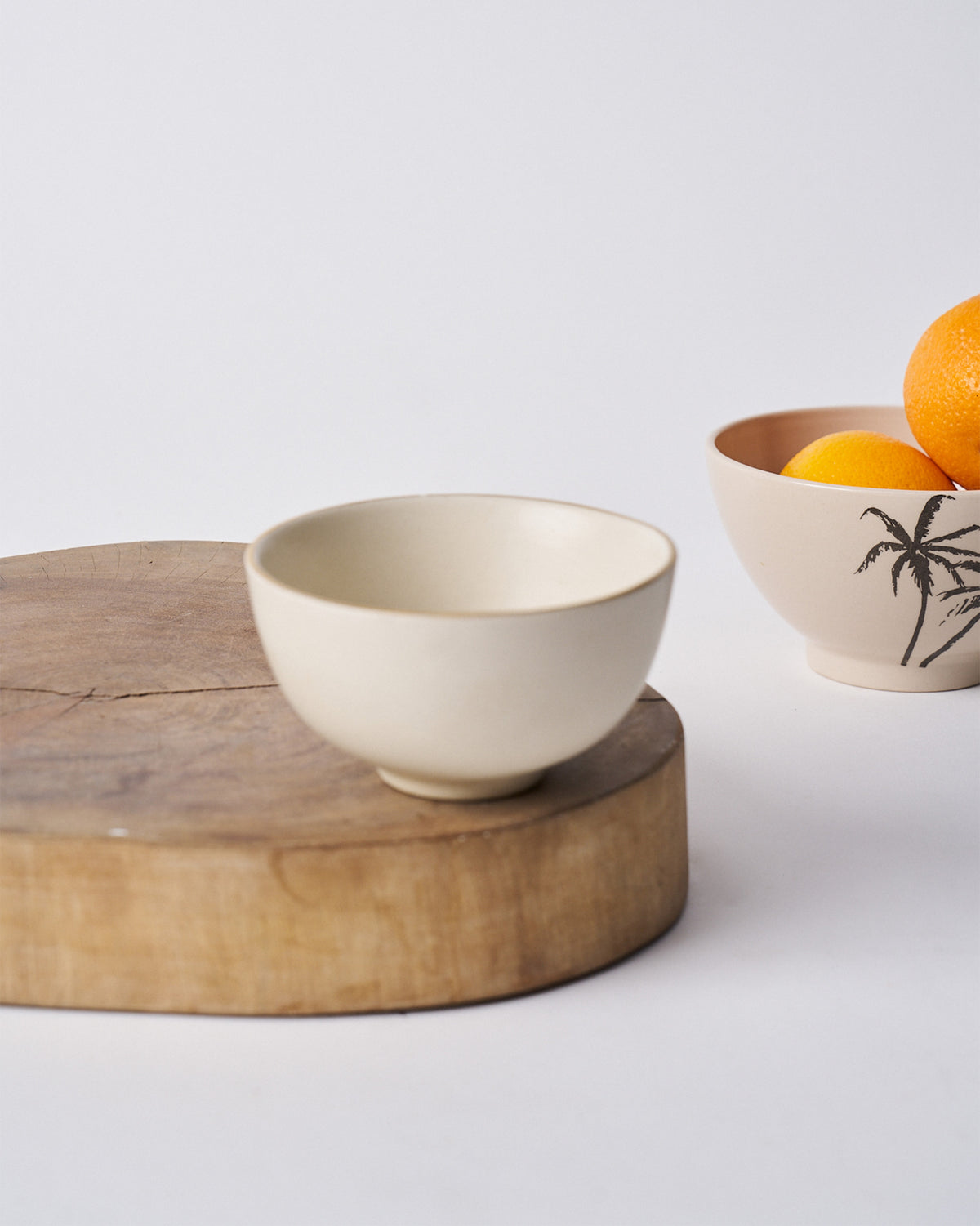 Tara Katori cream bowl on a wooden board.