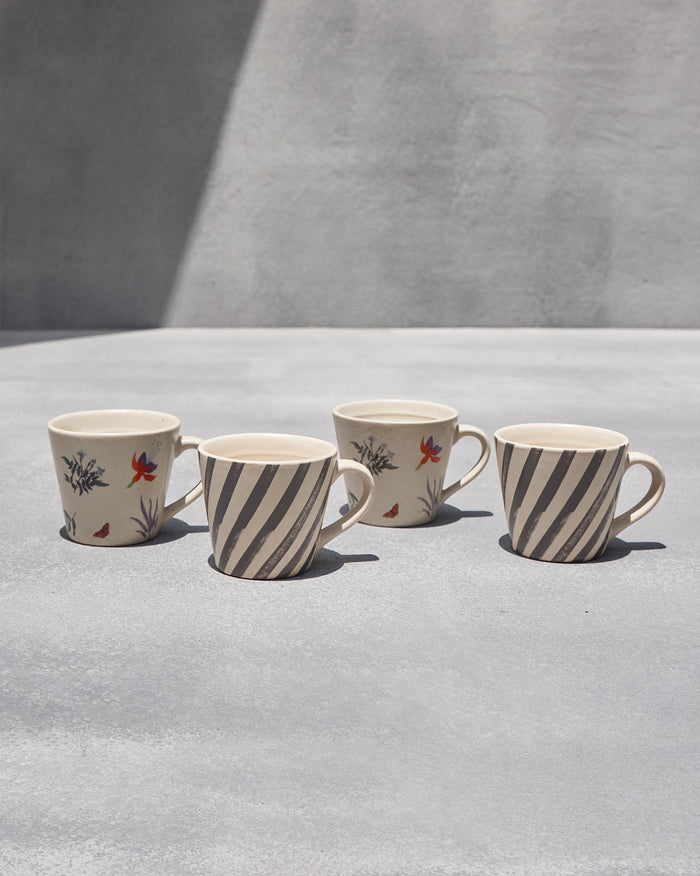 Set of four ivory Nanjing espresso mugs in stripe and blossom prints.