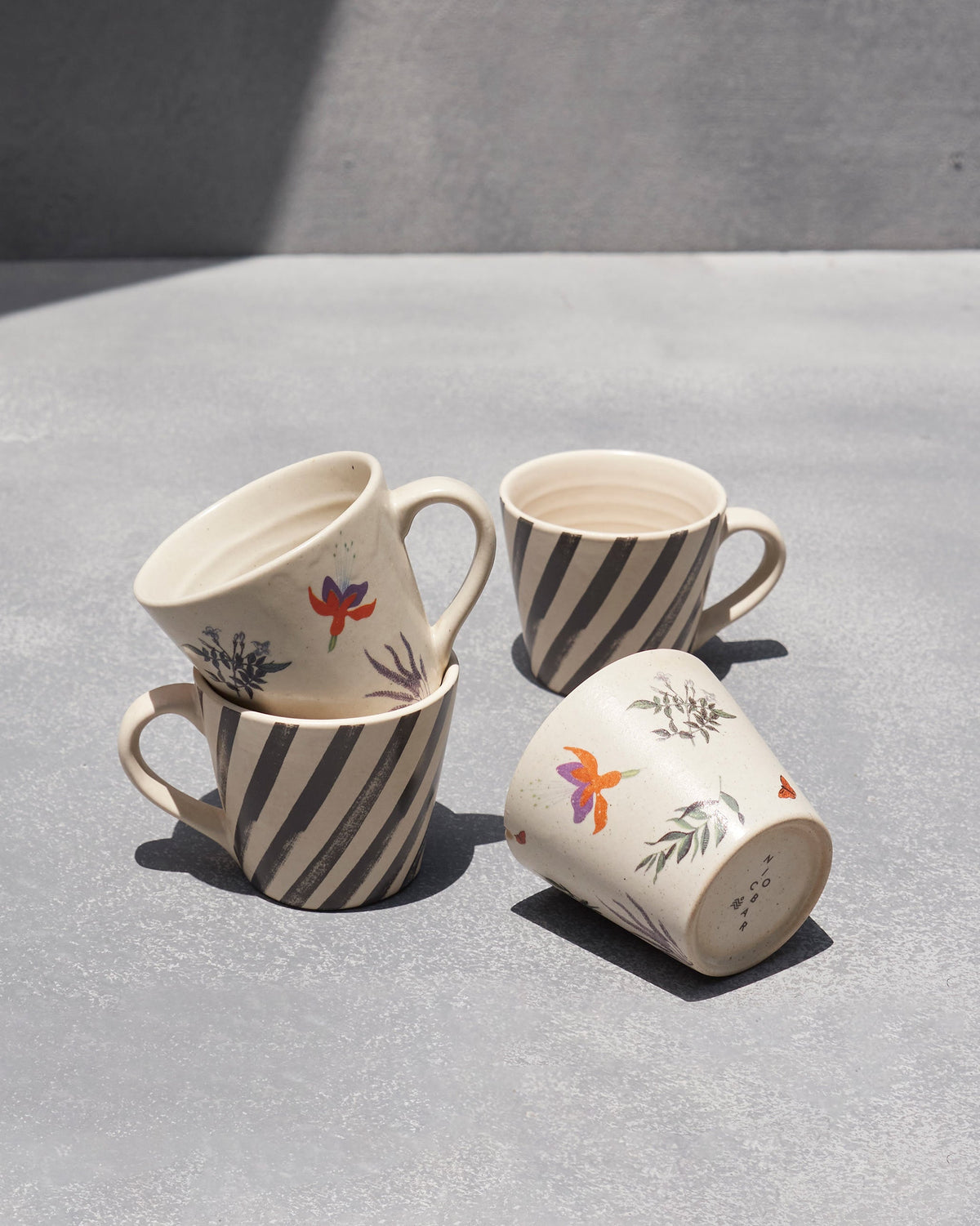 Tropic Espresso Mugs with stripes and orange and purple bird motifs.