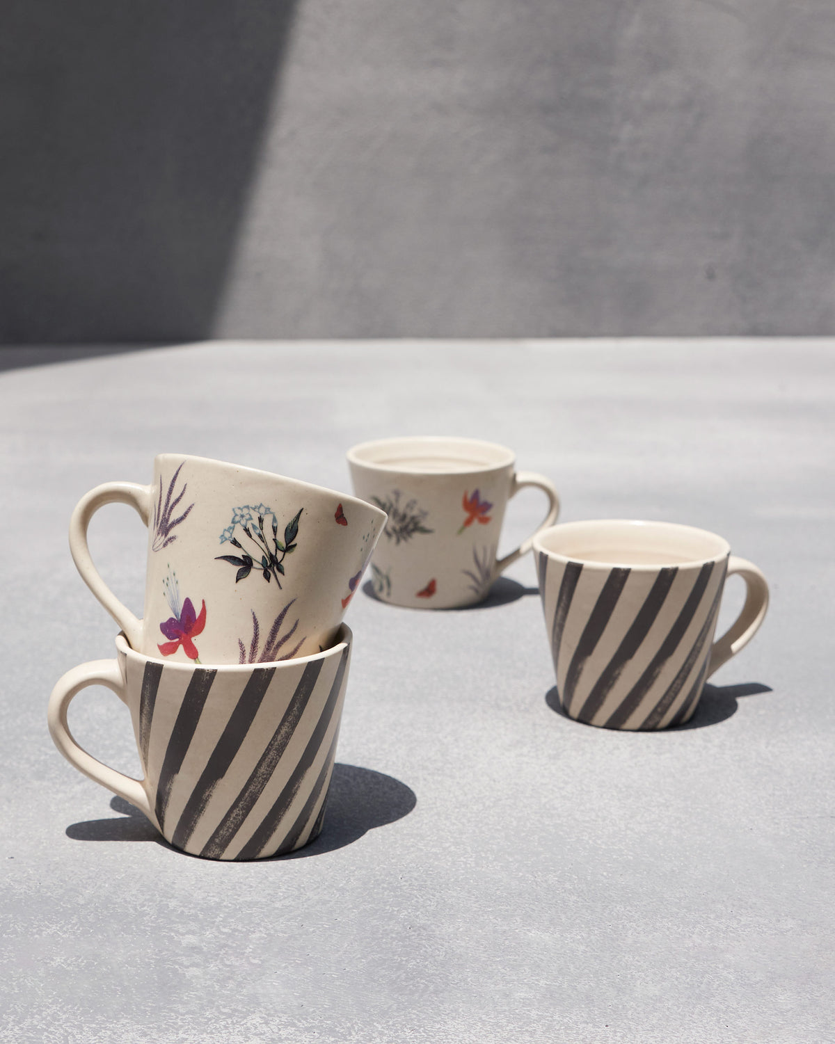 Stacked Nanjing espresso mugs mixing diagonal stripe and blossom prints.