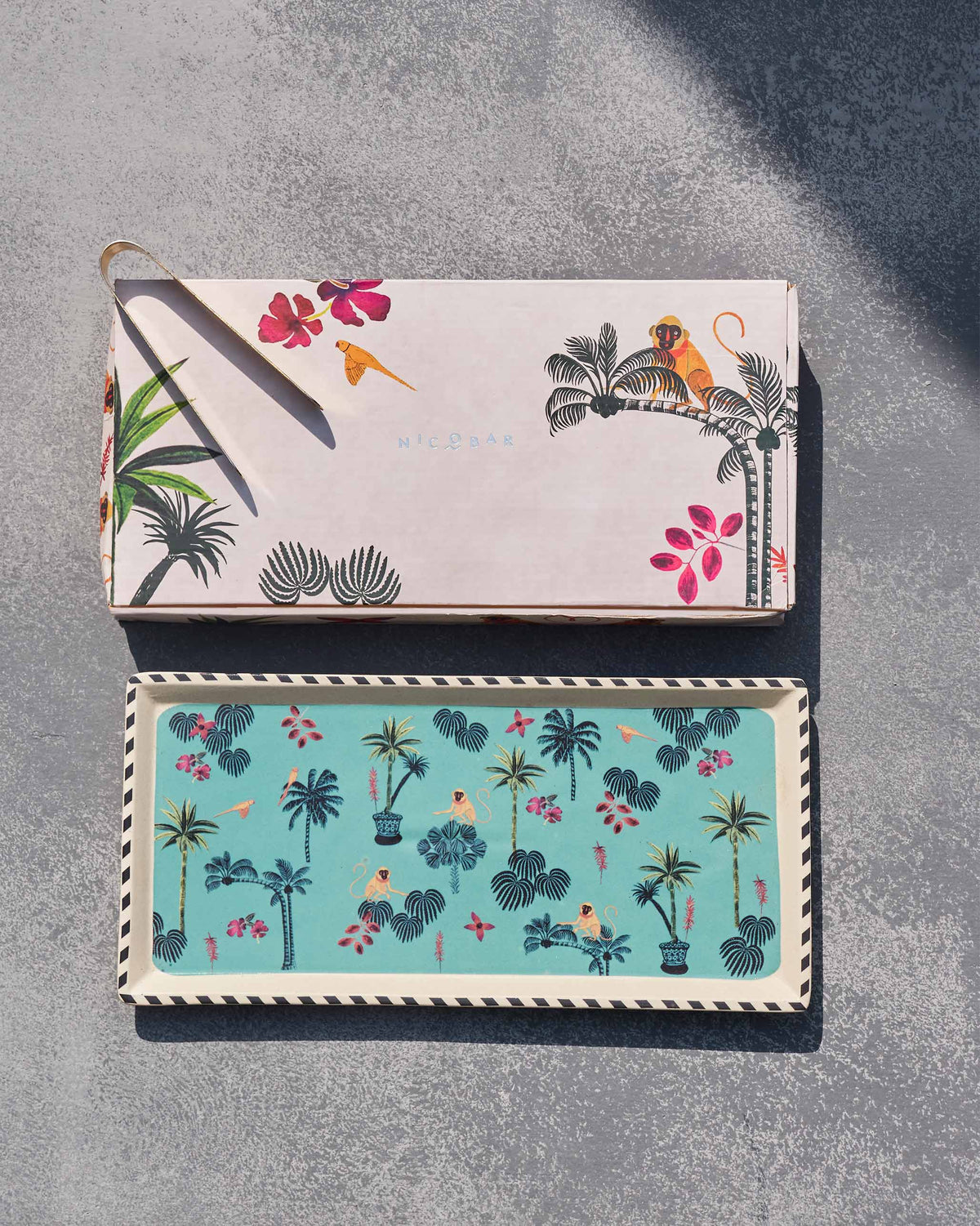 Tropico cookie tray with tongs beside its matching illustrated gift box.