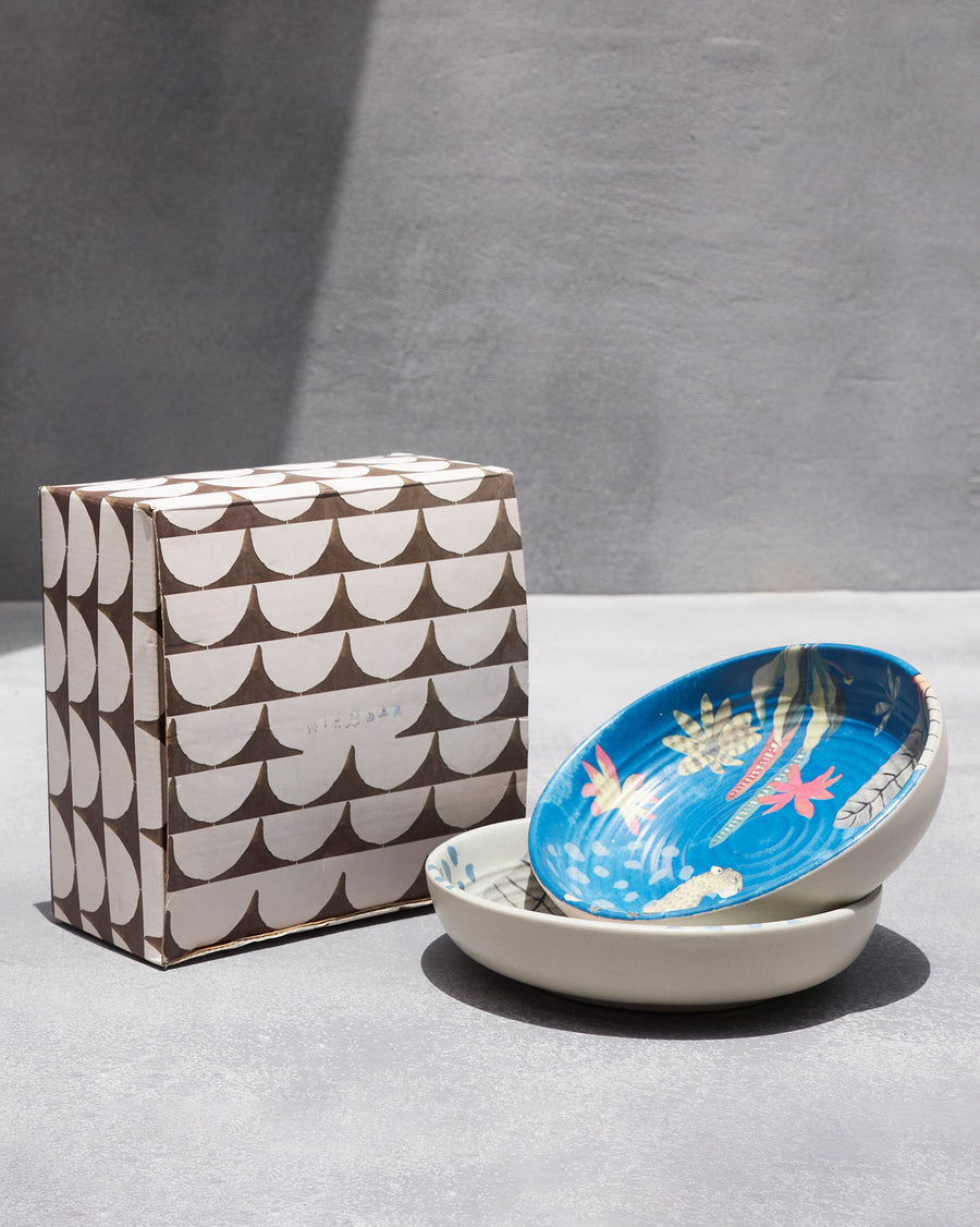 The bowls stacked beside a patterned gift box