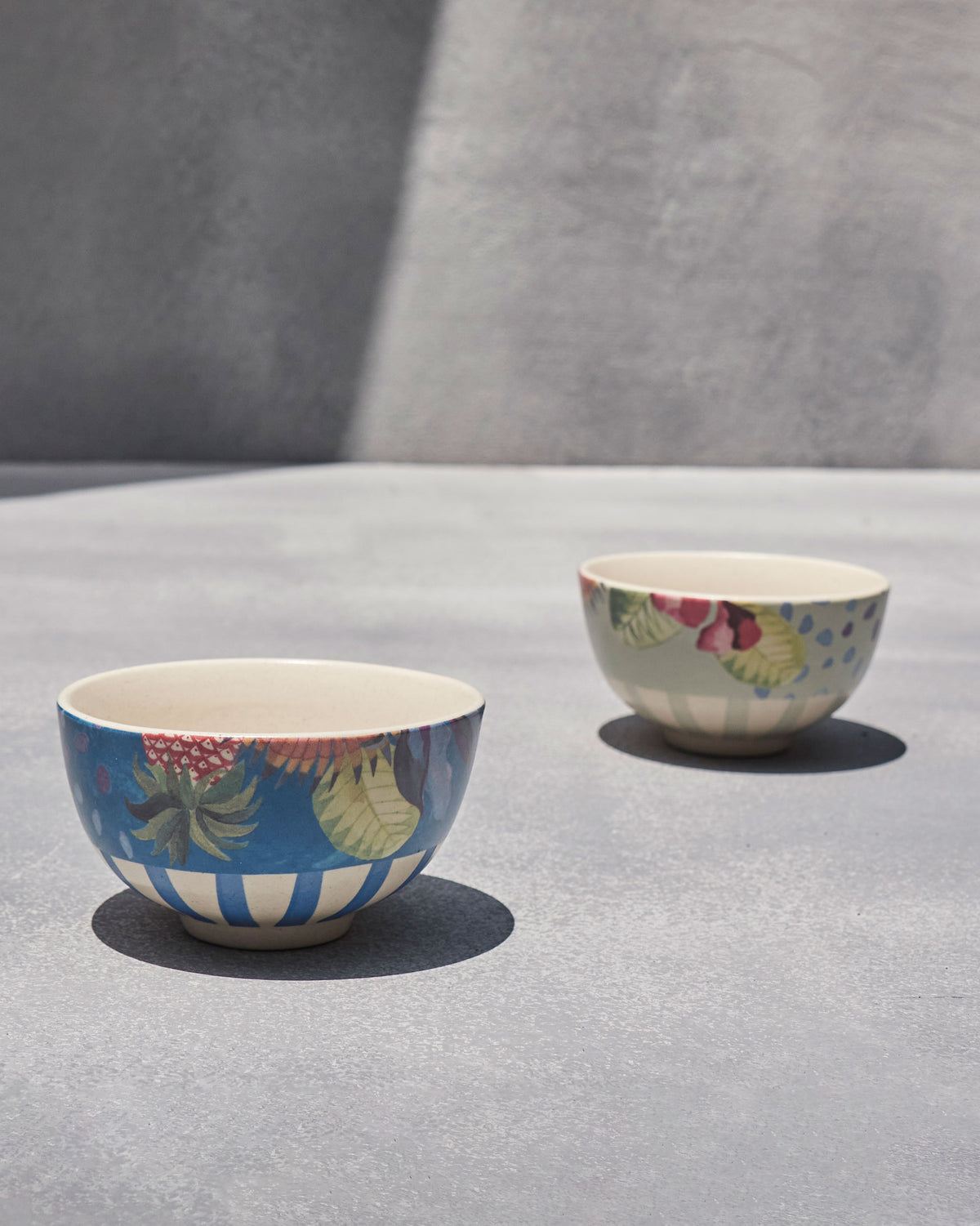 Blue Mahi nibble bowl with a fruit motif beside a pale grey-green bowl.