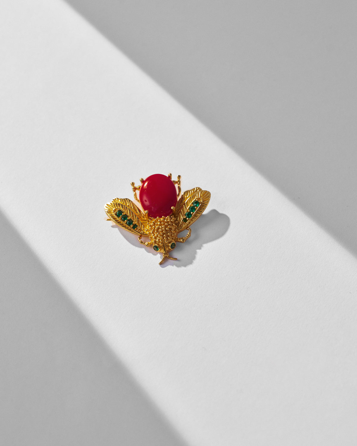 Gold Bug brooch shaped as a winged insect with a red stone body.