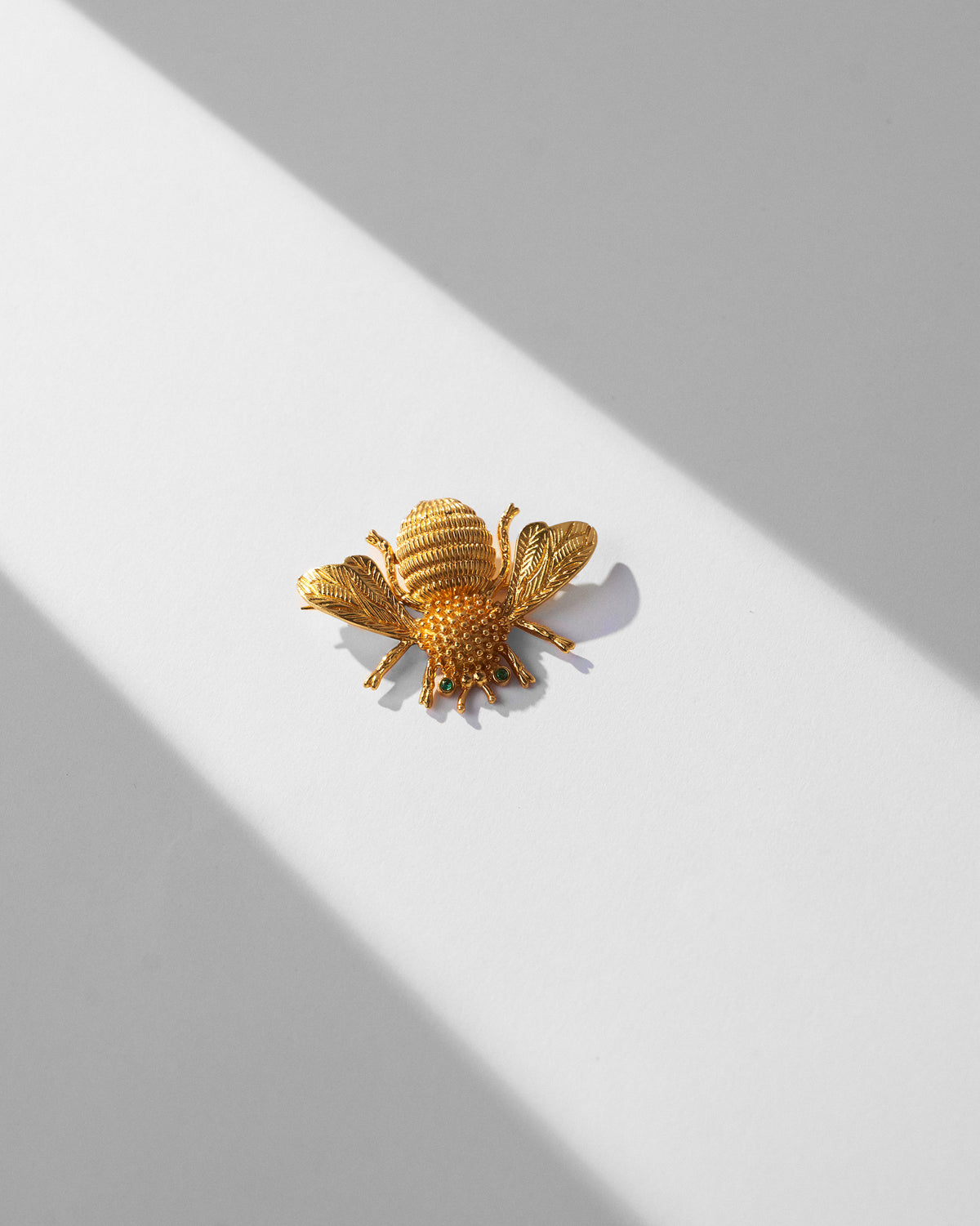 Gold Bee brooch showing ridged abdomen, legs and detailed wings.