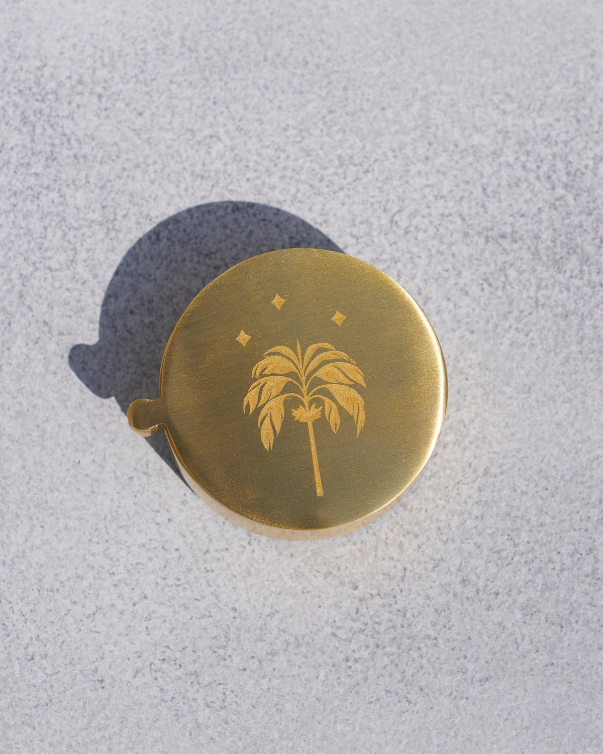 The gold Waadi Kesar Box with a palm etched on the lid.