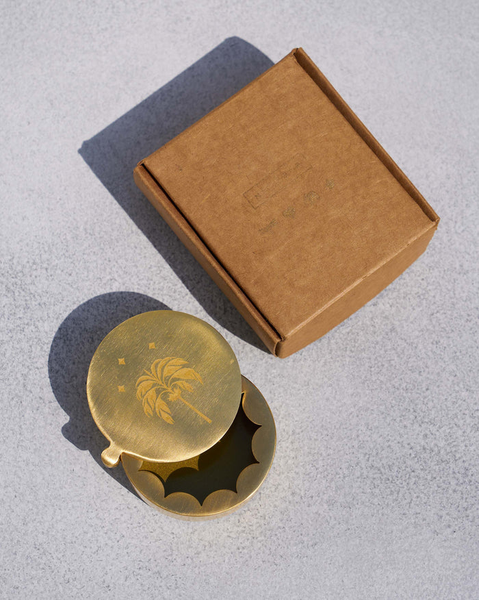 Gold Waadi kesar box partly open beside its kraft gift box.