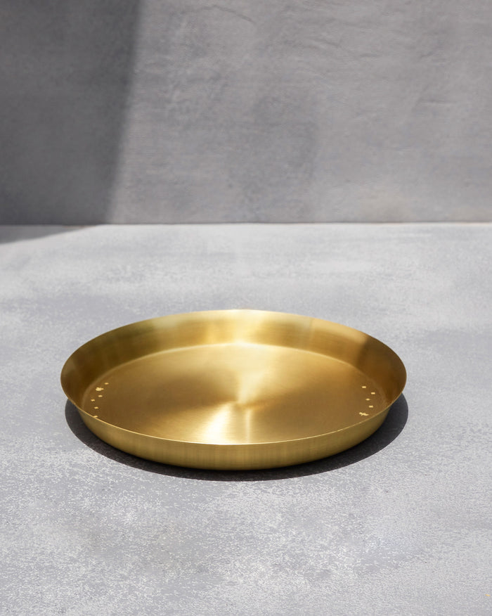 Large brushed brass Madhu thali with small star motifs.