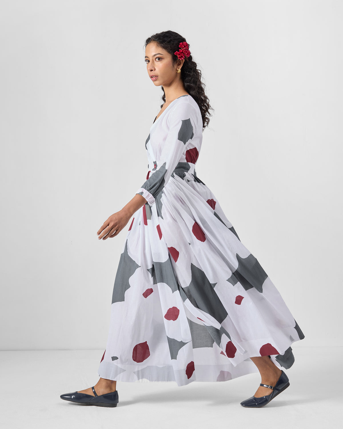 Side view of a white Nico wrap dress with a full flowing skirt.