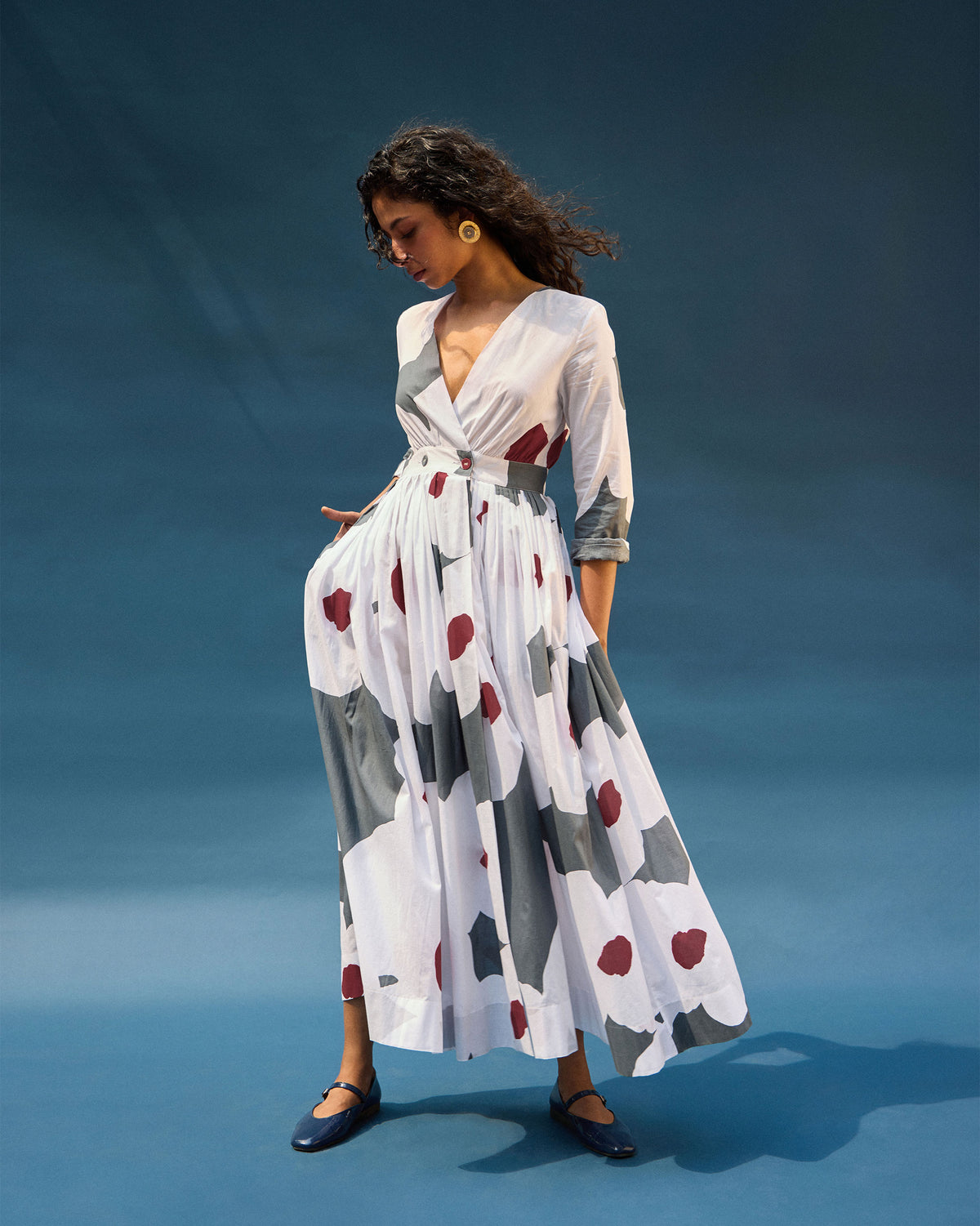 Person wearing a white Nico wrap dress with grey and maroon abstract print.