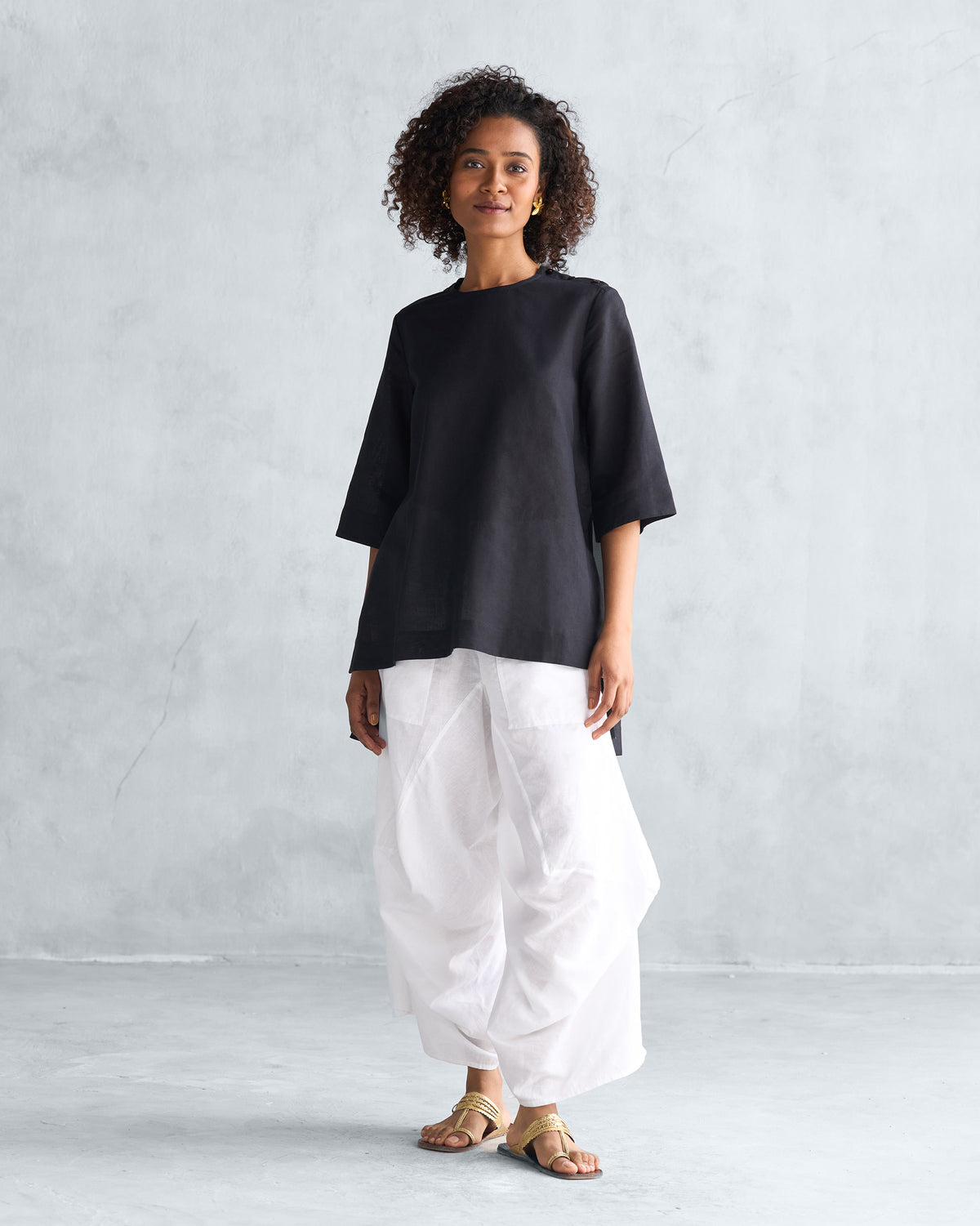 Person wearing a black High Slit Top with a relaxed mid-thigh length.