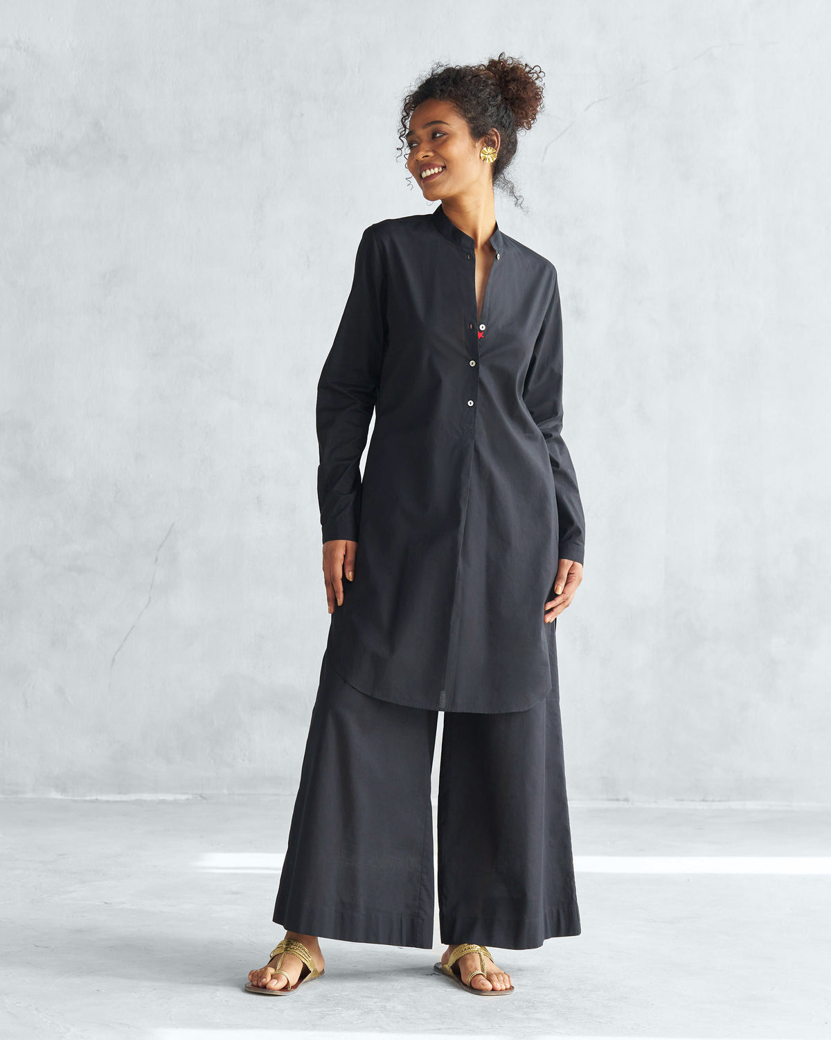 Person wearing black Basic Pyjamas tunic and matching wide-leg trousers.