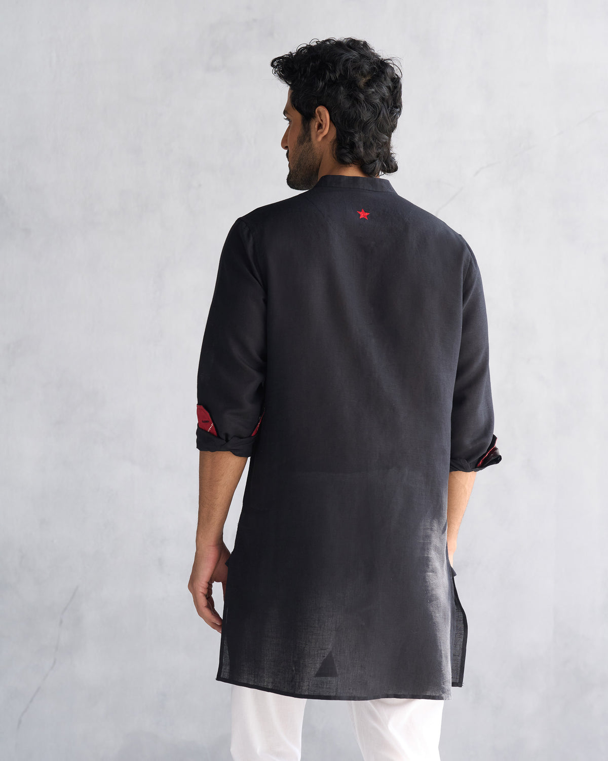 Back of a black Chandni Chowk kurta with a red embroidered star.