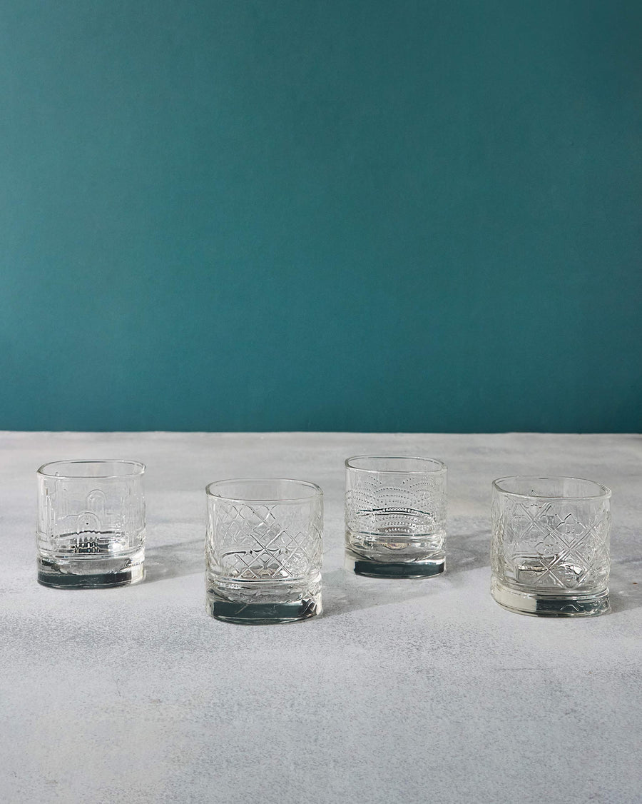 Four Mahi glasses in a row against a teal wall