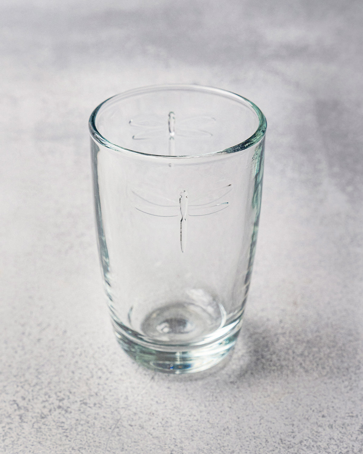 Tall clear Mahi long drink glass showing a dragonfly etch.