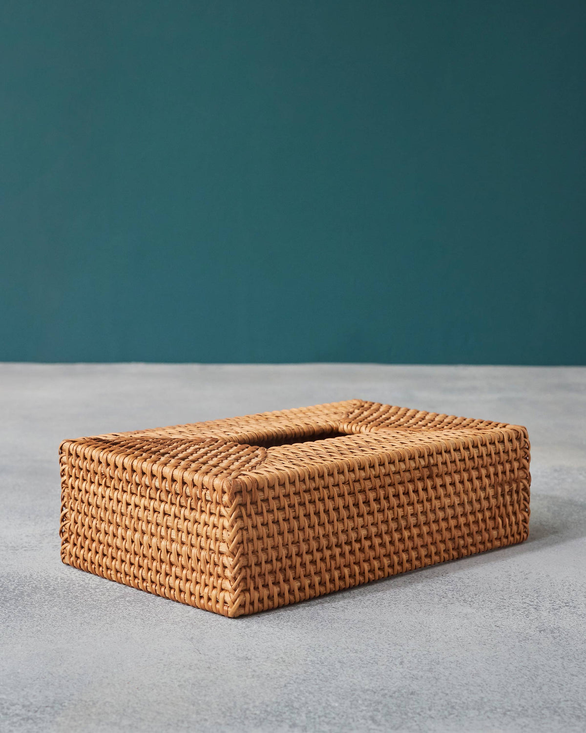 Rectangular honey rattan tissue cover showing its front face and top opening.