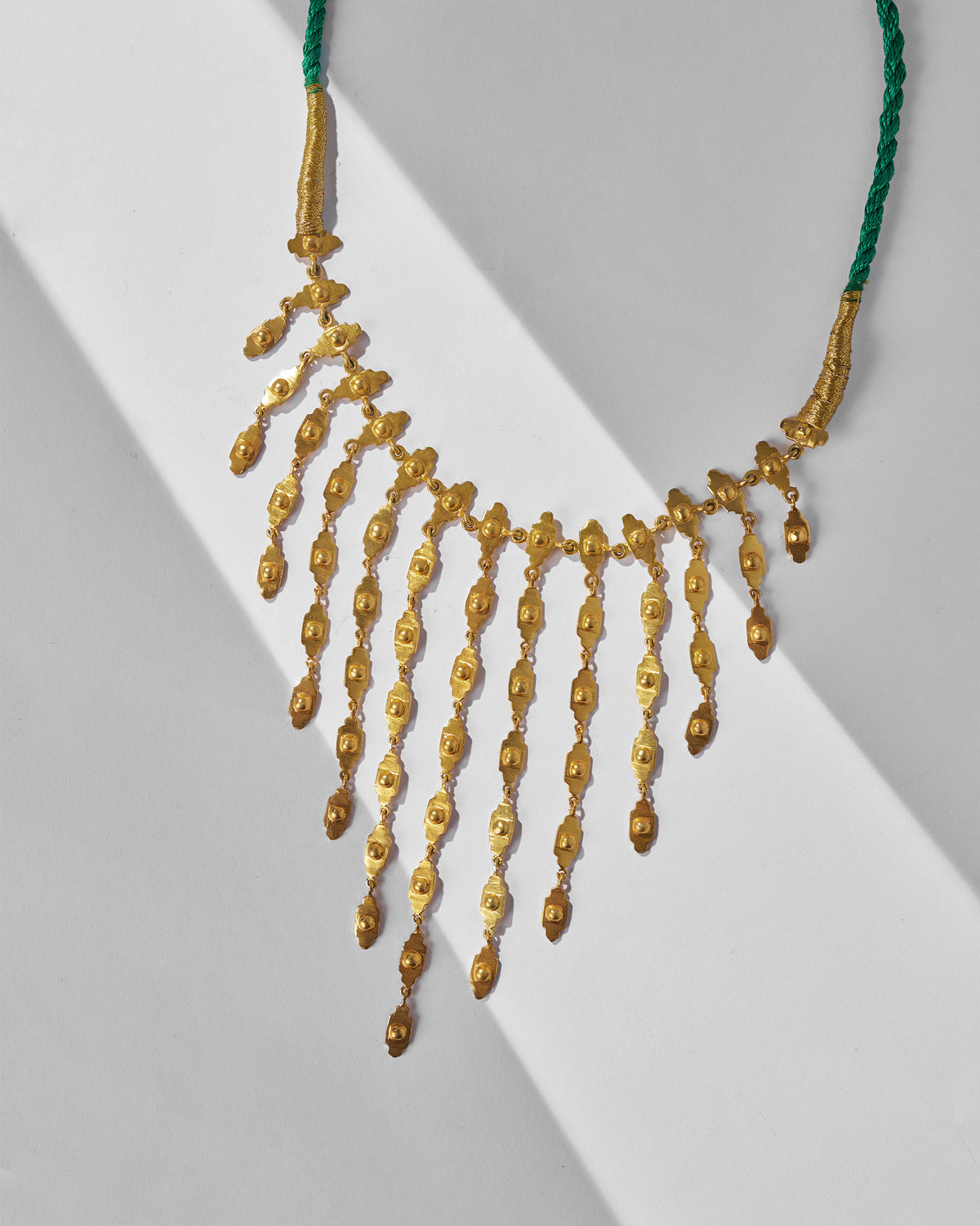 Close-up of gold zedi necklace fringe with textured links.