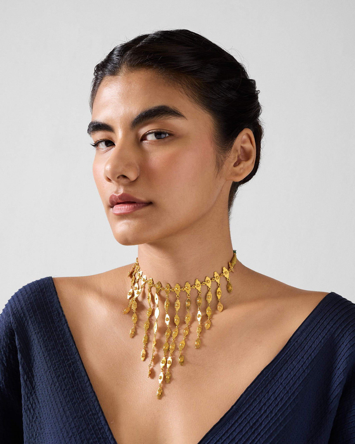 Person wearing a gold zedi necklace with a fringe bib.