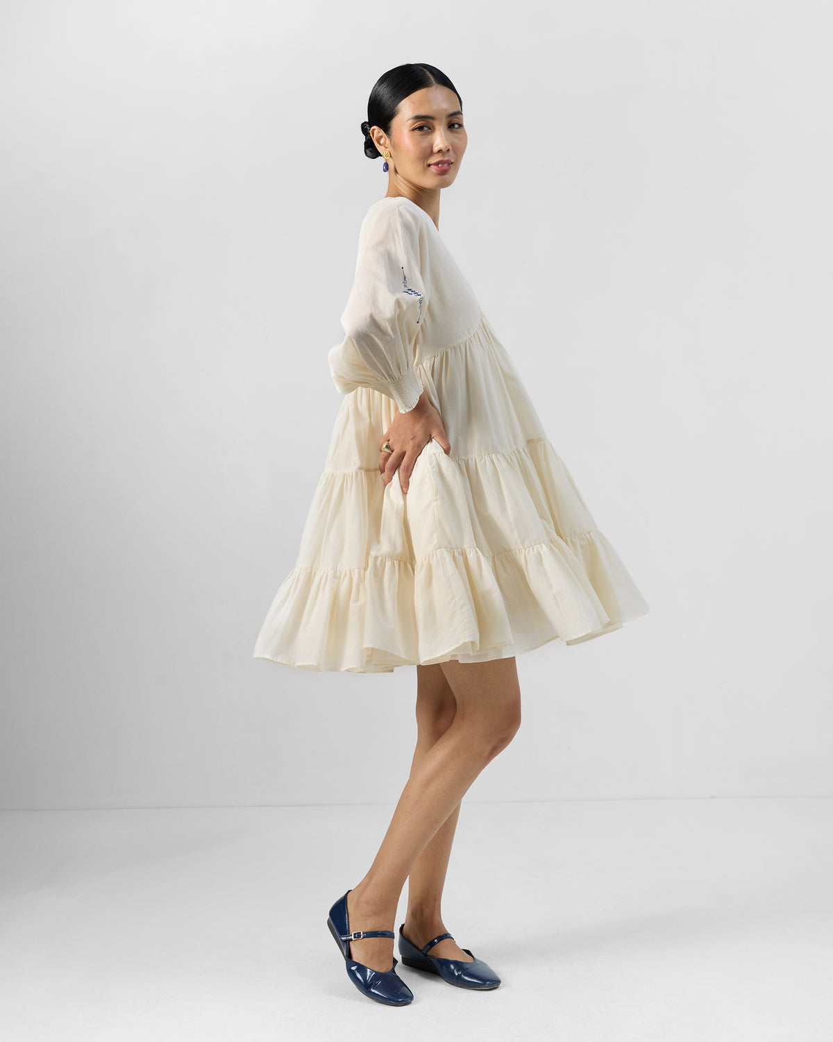 Side view of an ivory Temple tier dress with a side pocket.