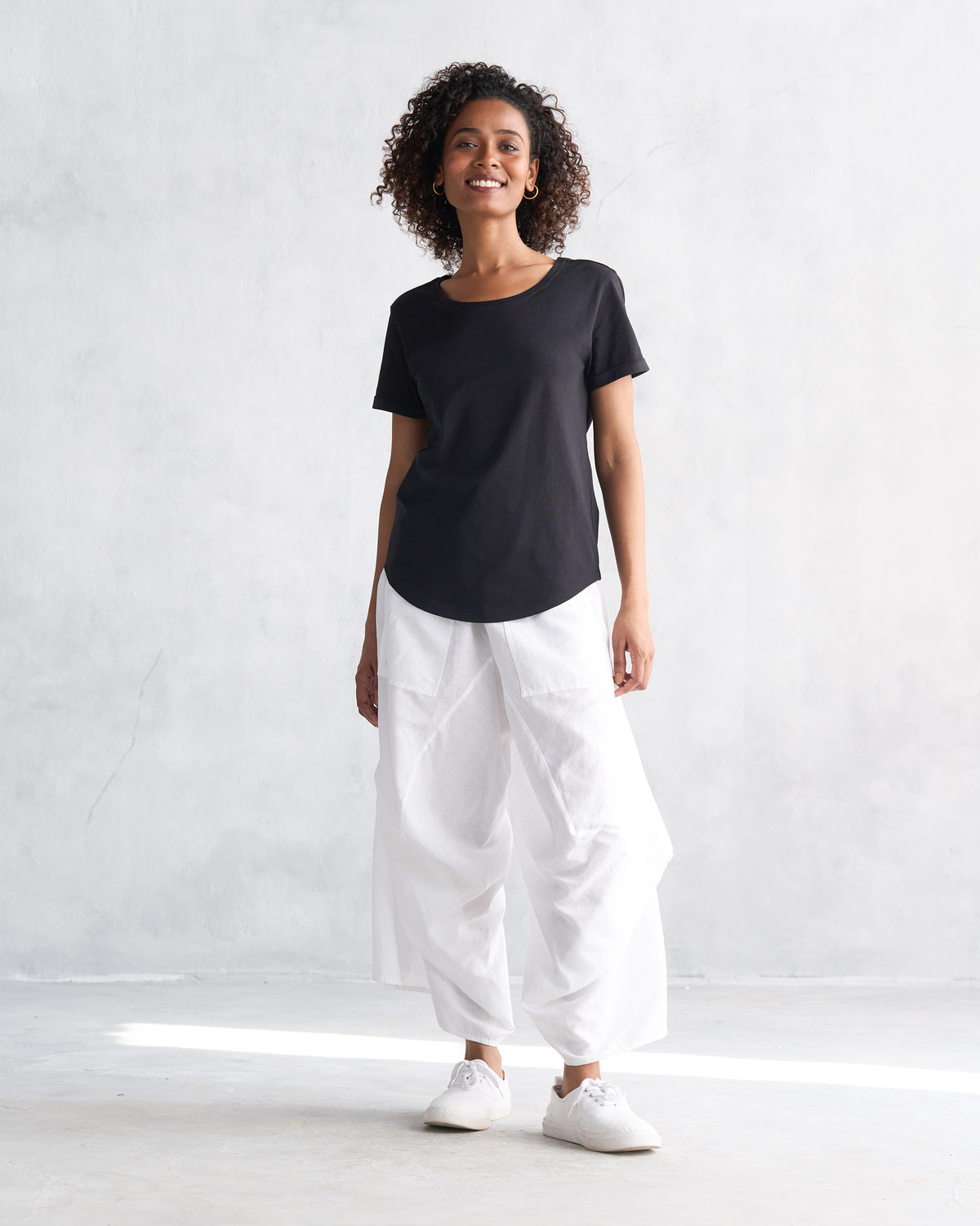 Person wearing white Yoka Trousers with a loose, wide leg.