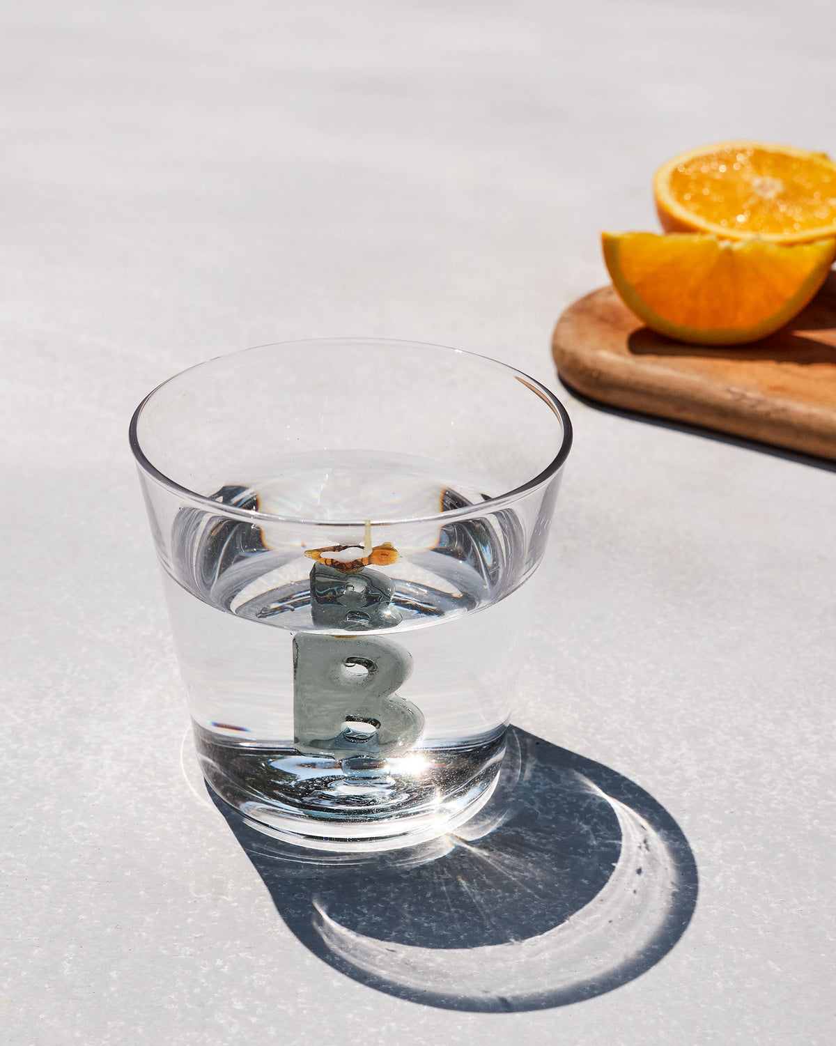 Clear Alphabet glass with a 3D letter B at the base, filled with water.