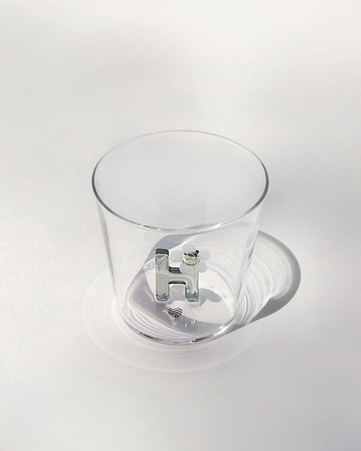 Clear tumbler with a 3D letter H topped by a white flower at the base.