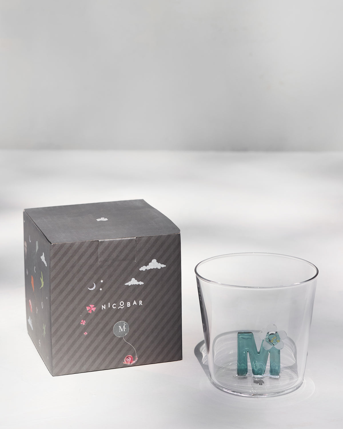 The M Alphabet glass filled with water.