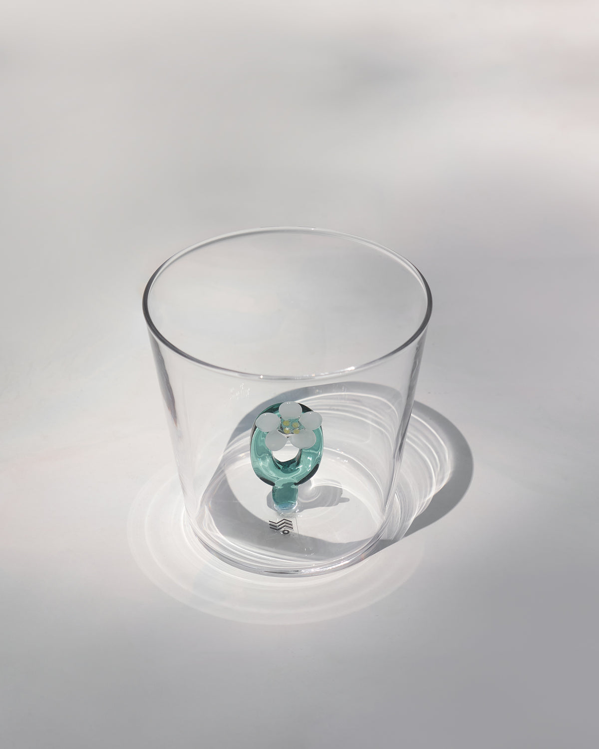 Clear Alphabet glass showing a teal letter O with a white flower at the base.