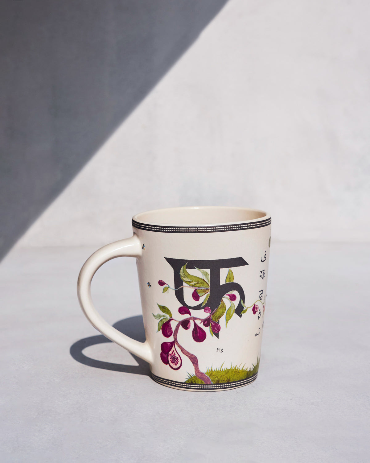 Firefly mug reverse with Devanagari फ़ and a painted fig plant.