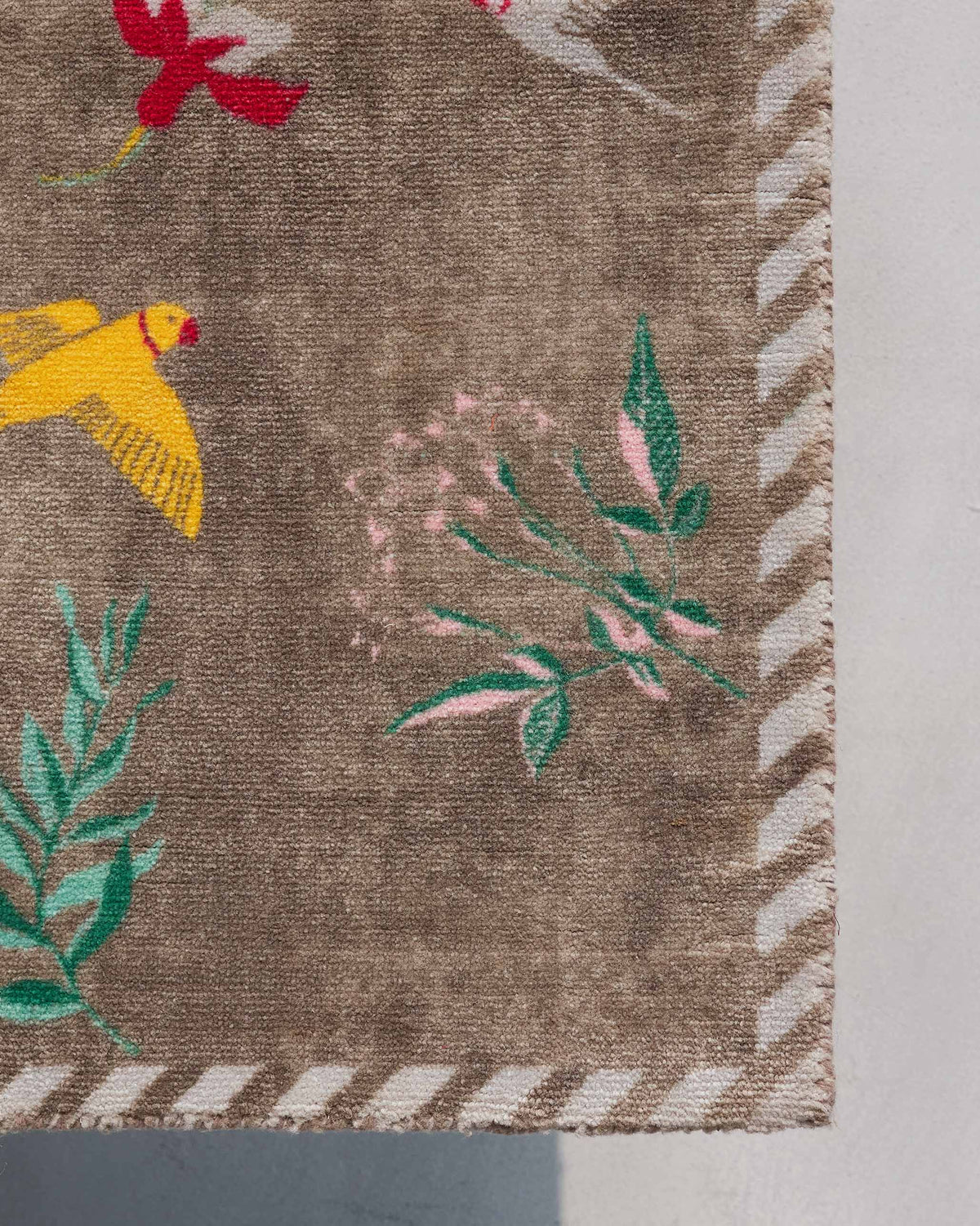 Corner of Liba Rug showing its striped border and leafy motifs.