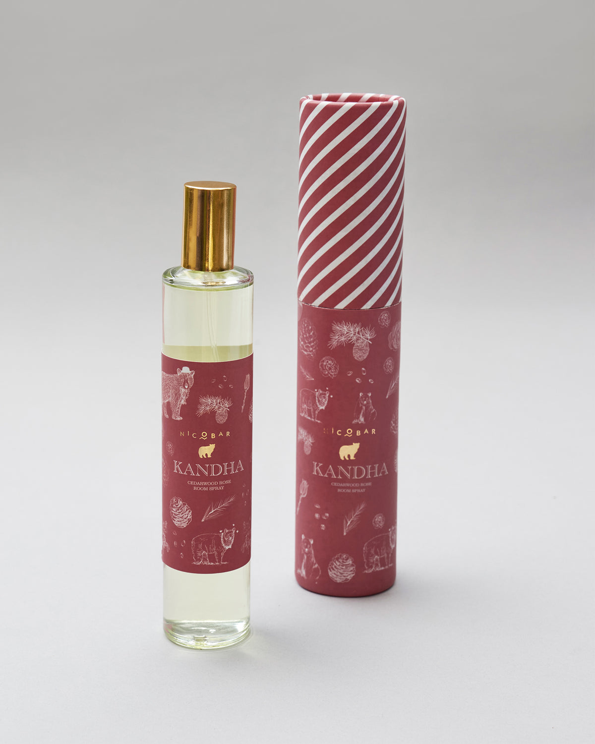Kandha room spray bottle standing beside its cylindrical gift tube.