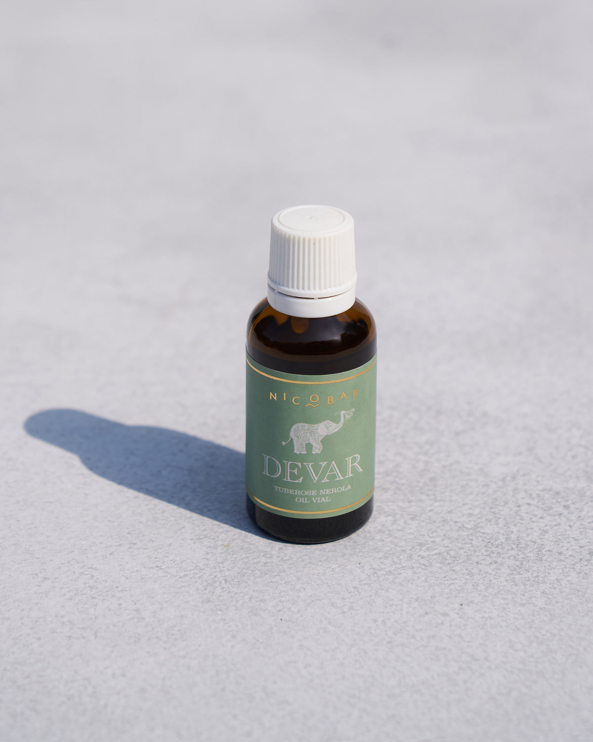 Angled view of a Devar oil vial showing its green label.