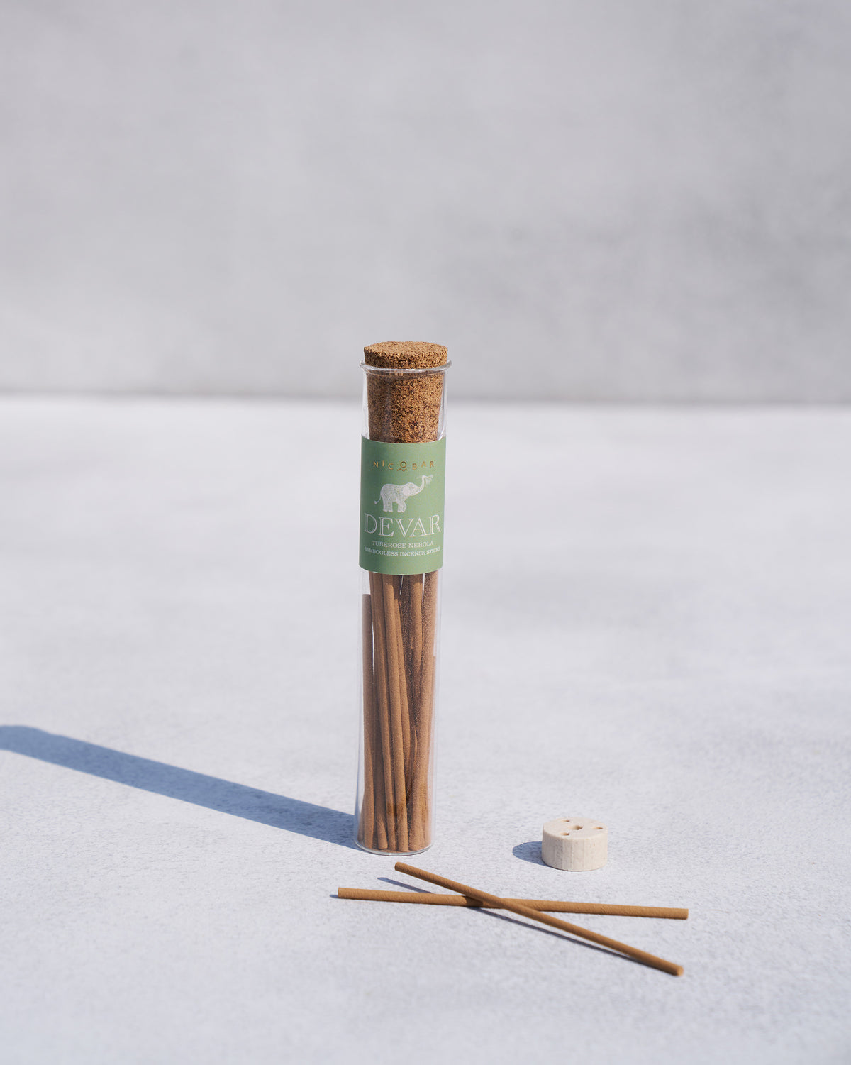 Devar incense sticks standing in a glass tube with a cork lid.