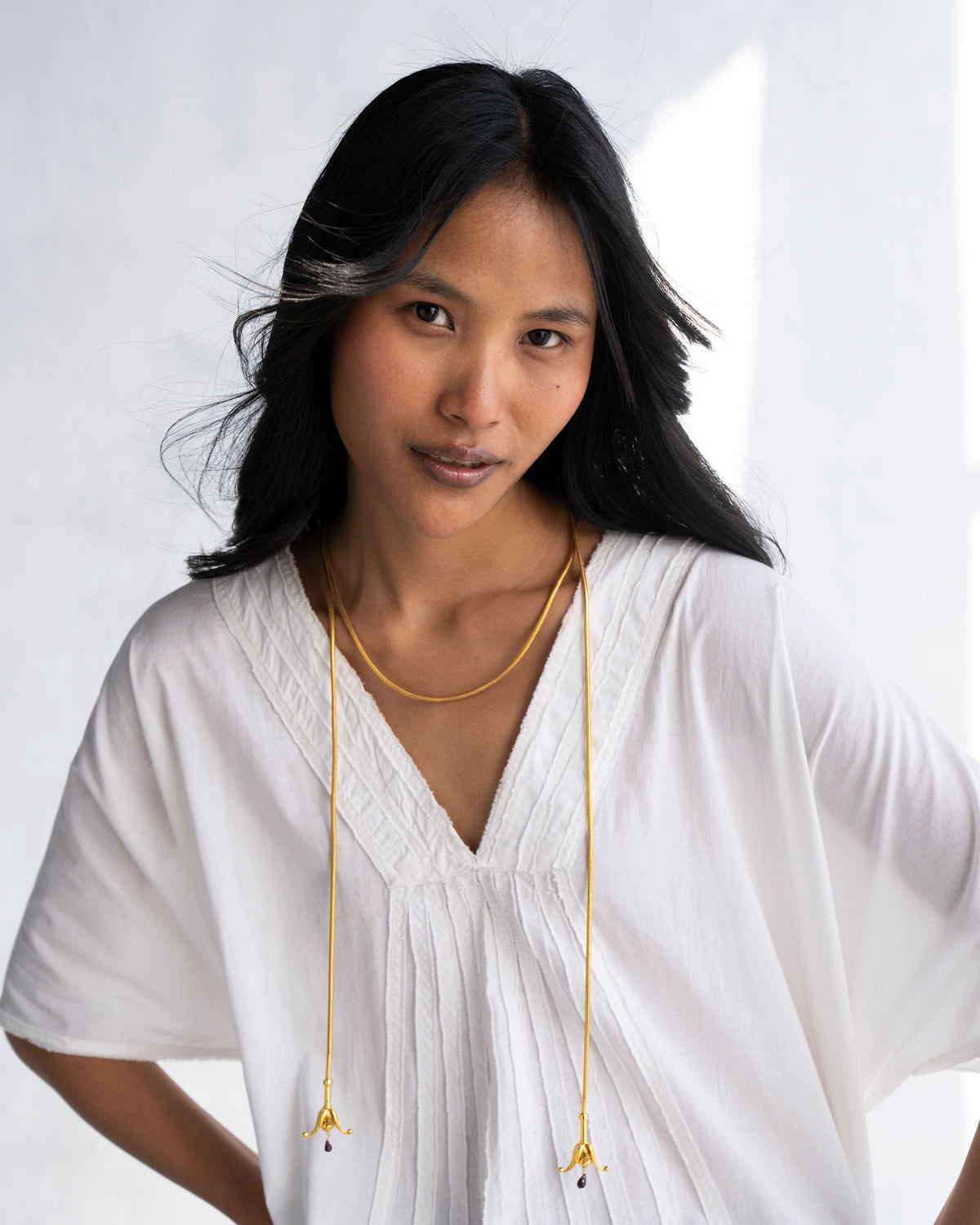 Person wearing a gold Phool Chain with flower-shaped ends tied at the front.