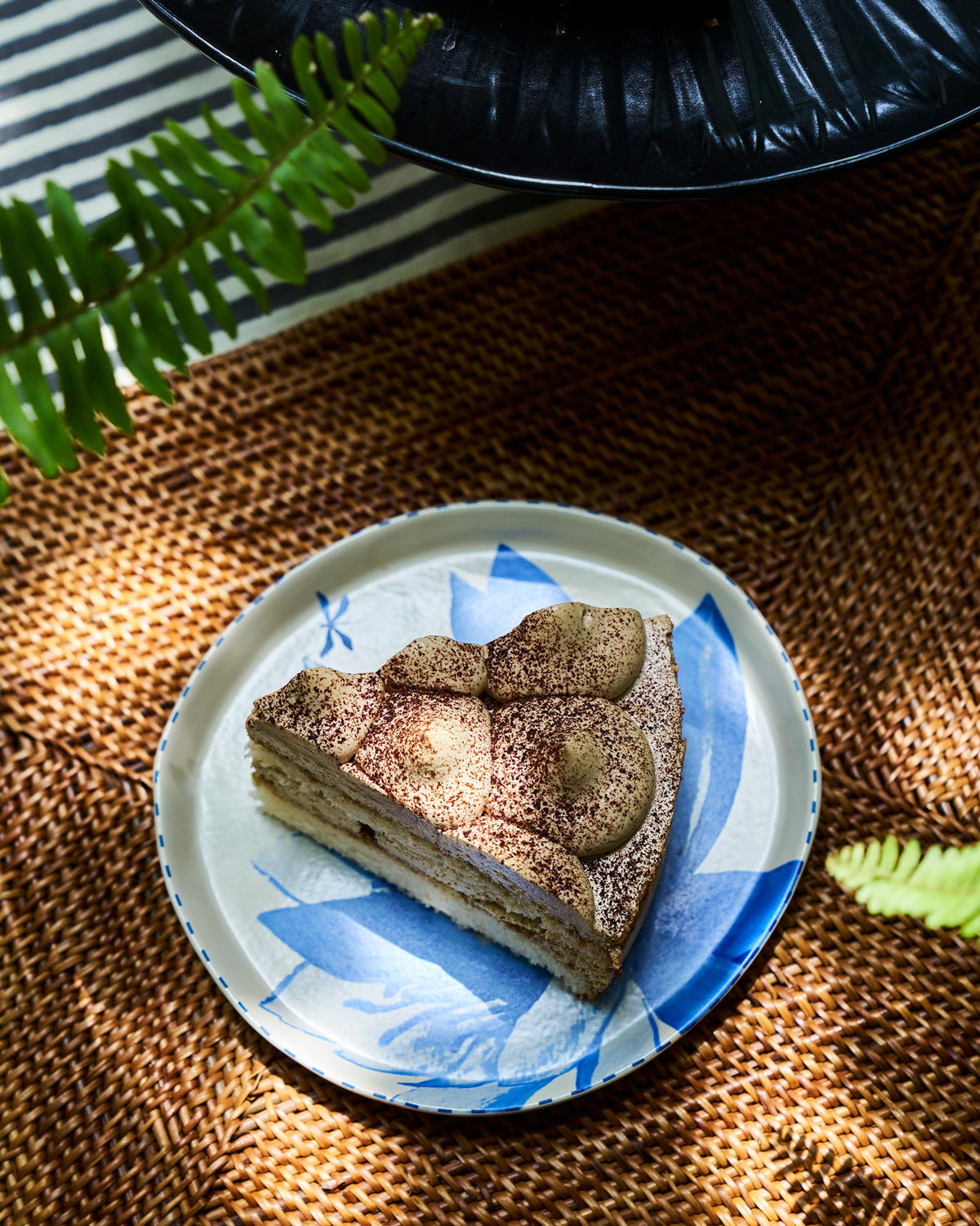 Seroja Dessert Plate with a blue lotus design, shown in use.