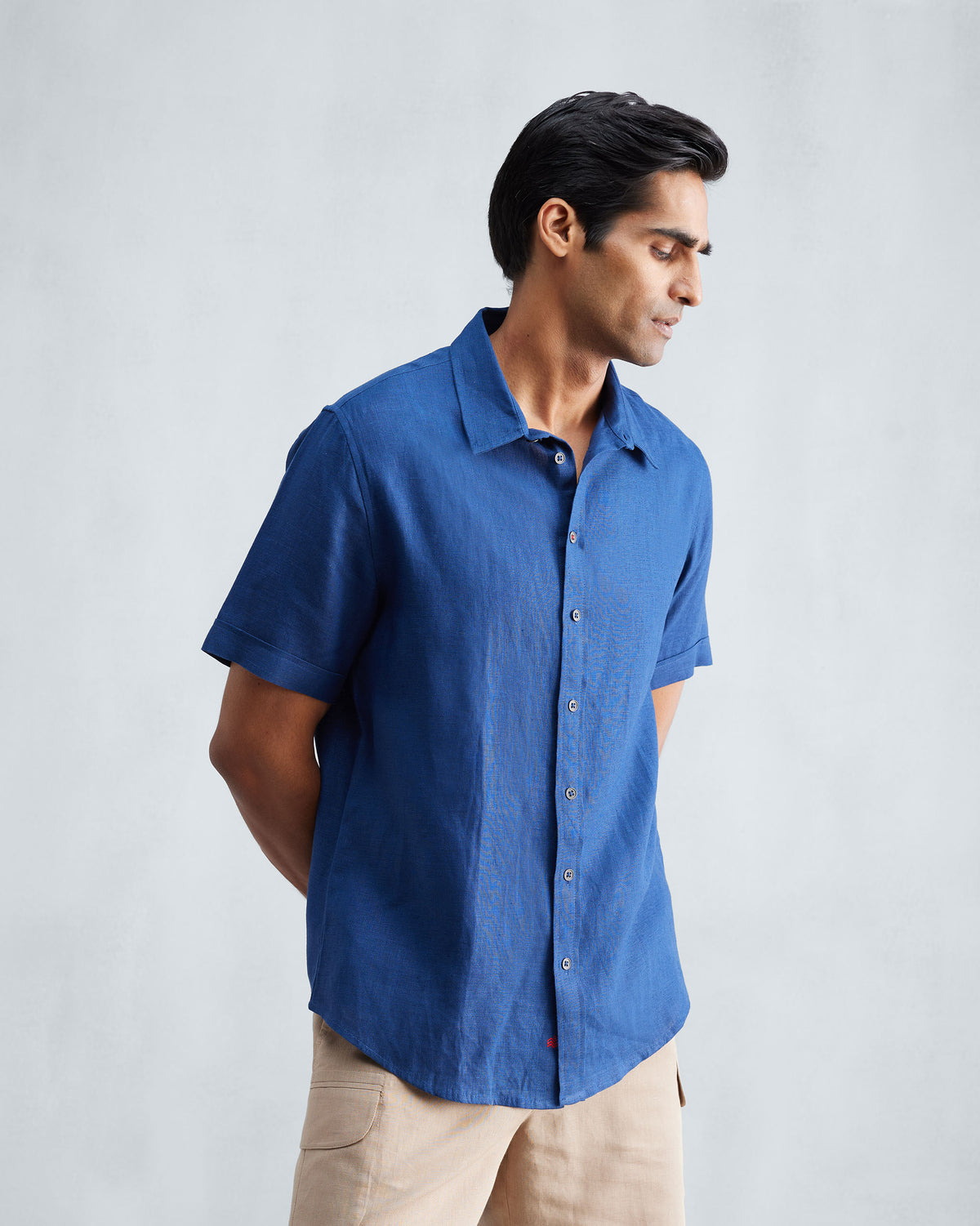 Three-quarter view of a navy Half Sleeve Shirt with a short sleeve and curved hem.