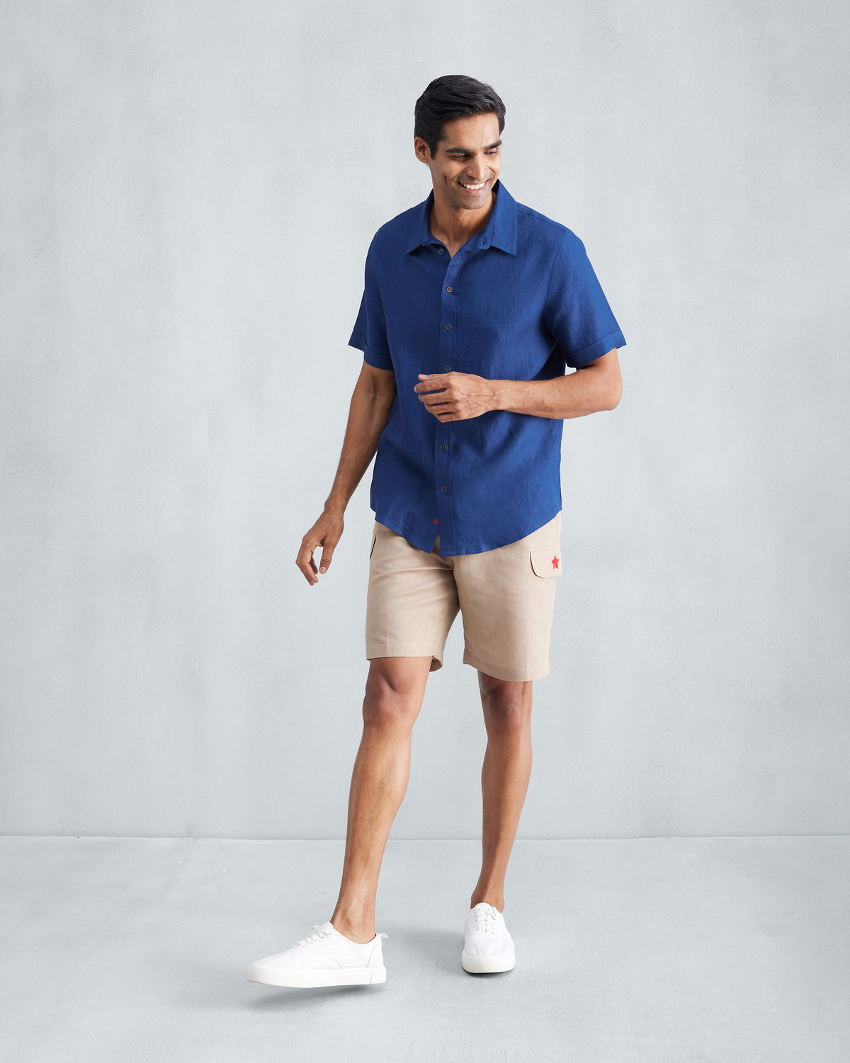 Person wearing a navy Half Sleeve Shirt with a short sleeve and classic collar.