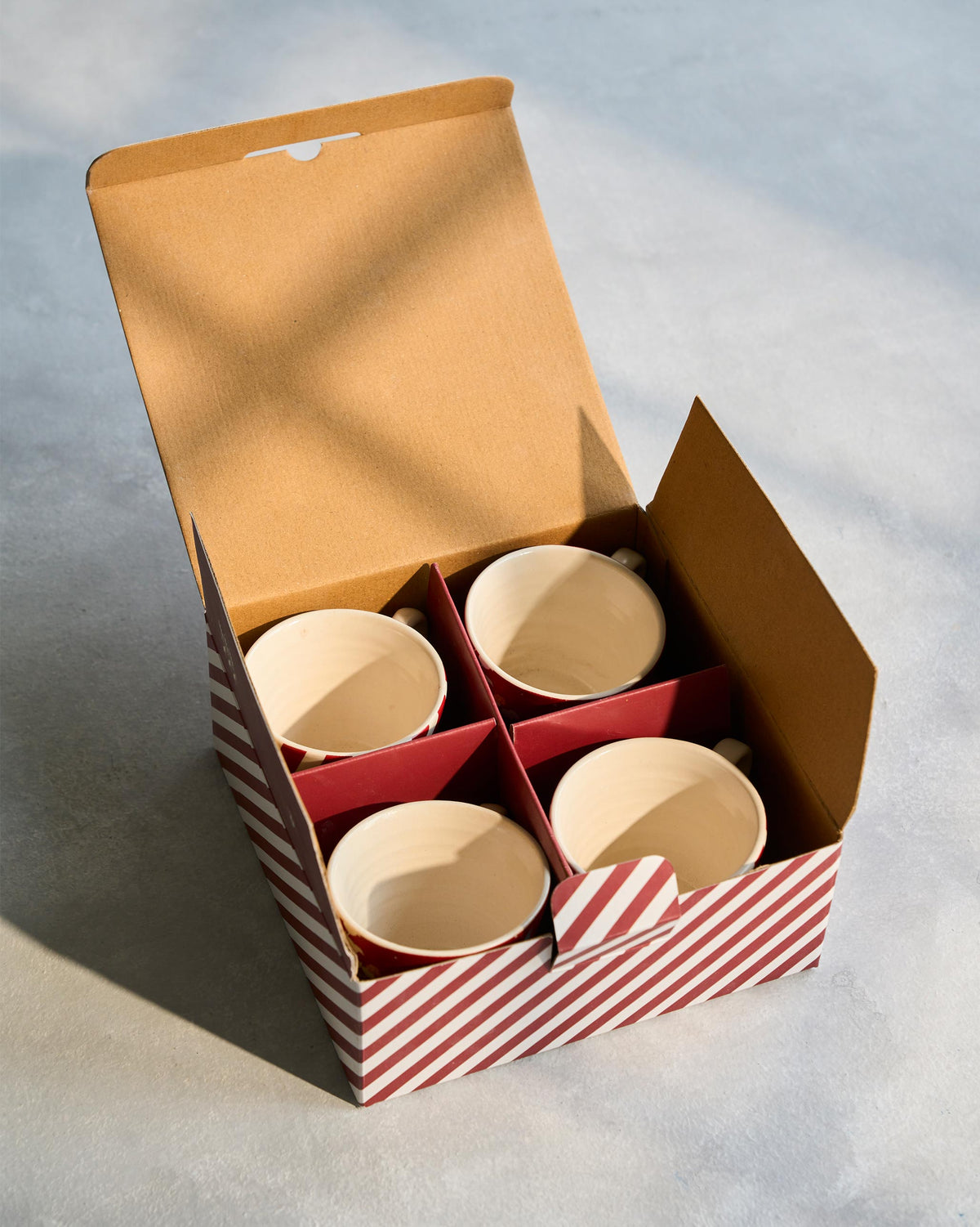 Phoenix espresso mug set of four packed in an open striped gift box.