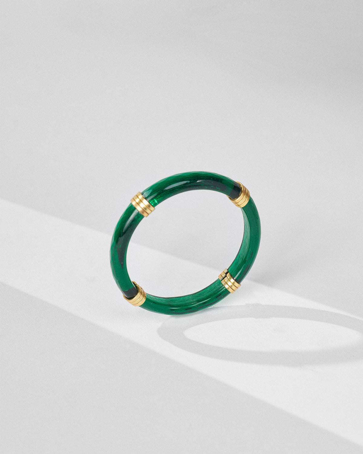 Green Cara glass bangle with four gold ribbed spacers.