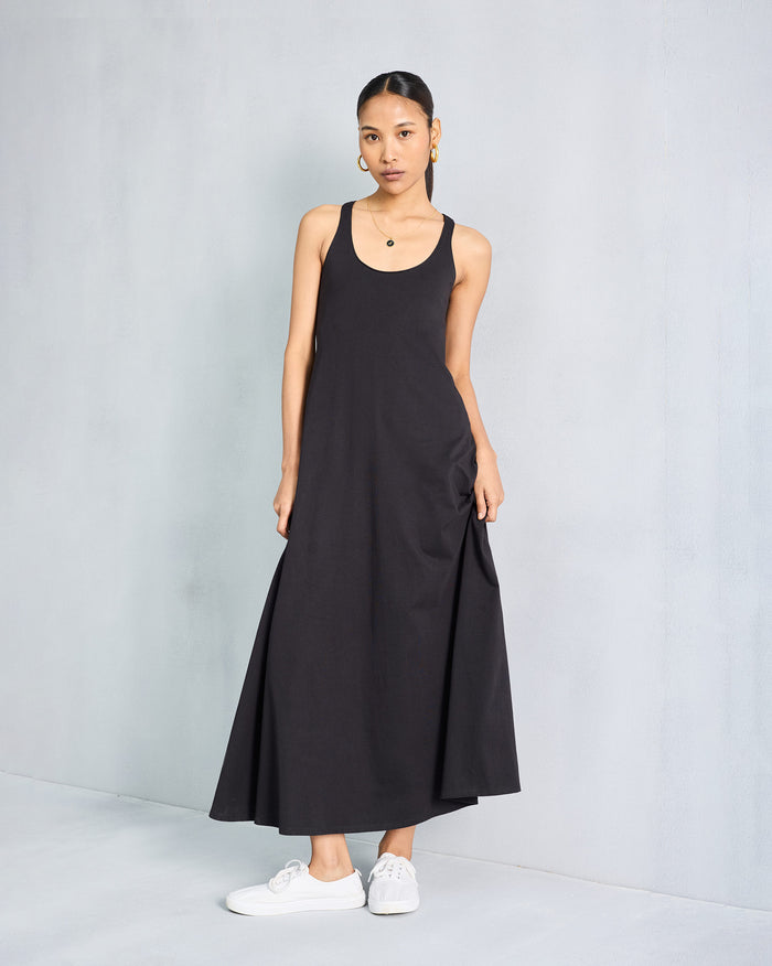 Person wearing a black sleeveless Esther dress with a scoop neck.