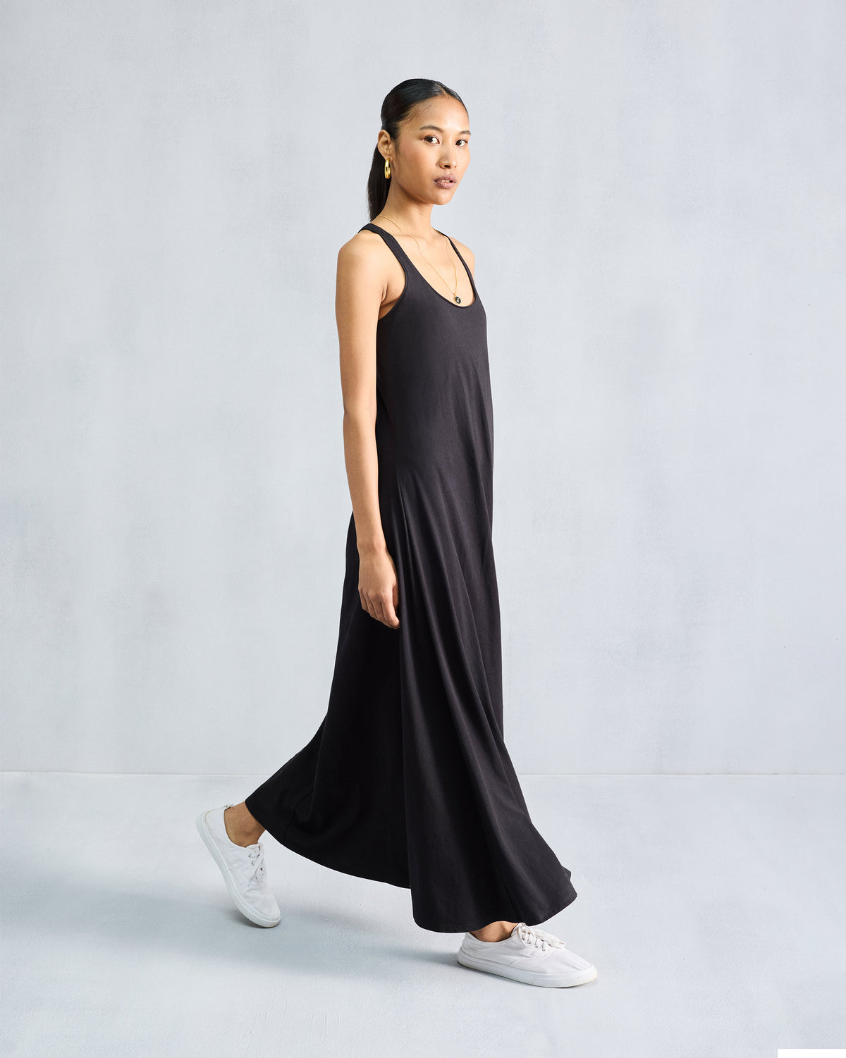 Side view of a black Esther dress showing the flowing A-line drape.